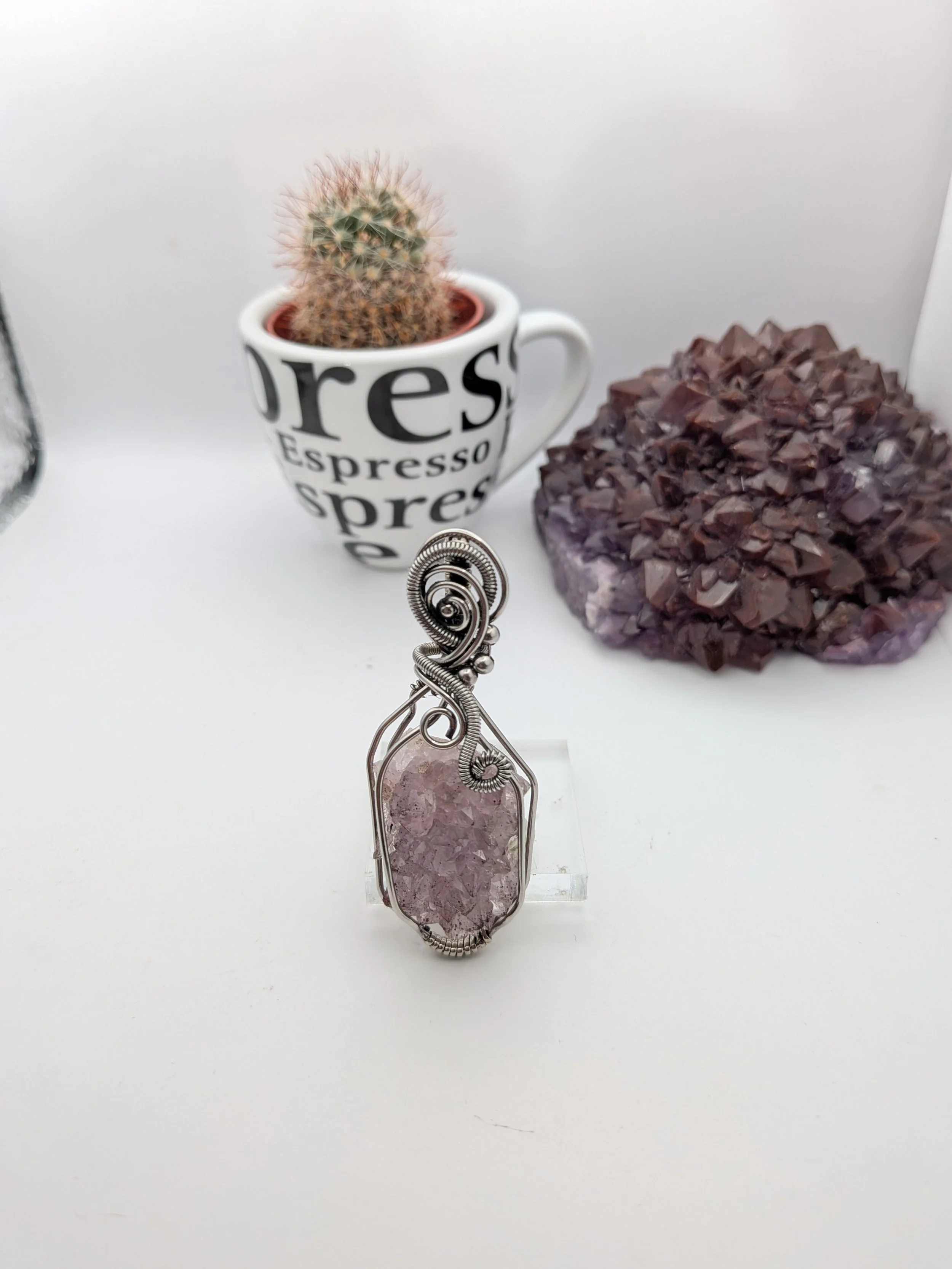 A stunning Thunder Bay amethyst cluster wrapped in stainless wire, elegantly accented with wavy stainless to highlight the amethyst as the focal point.