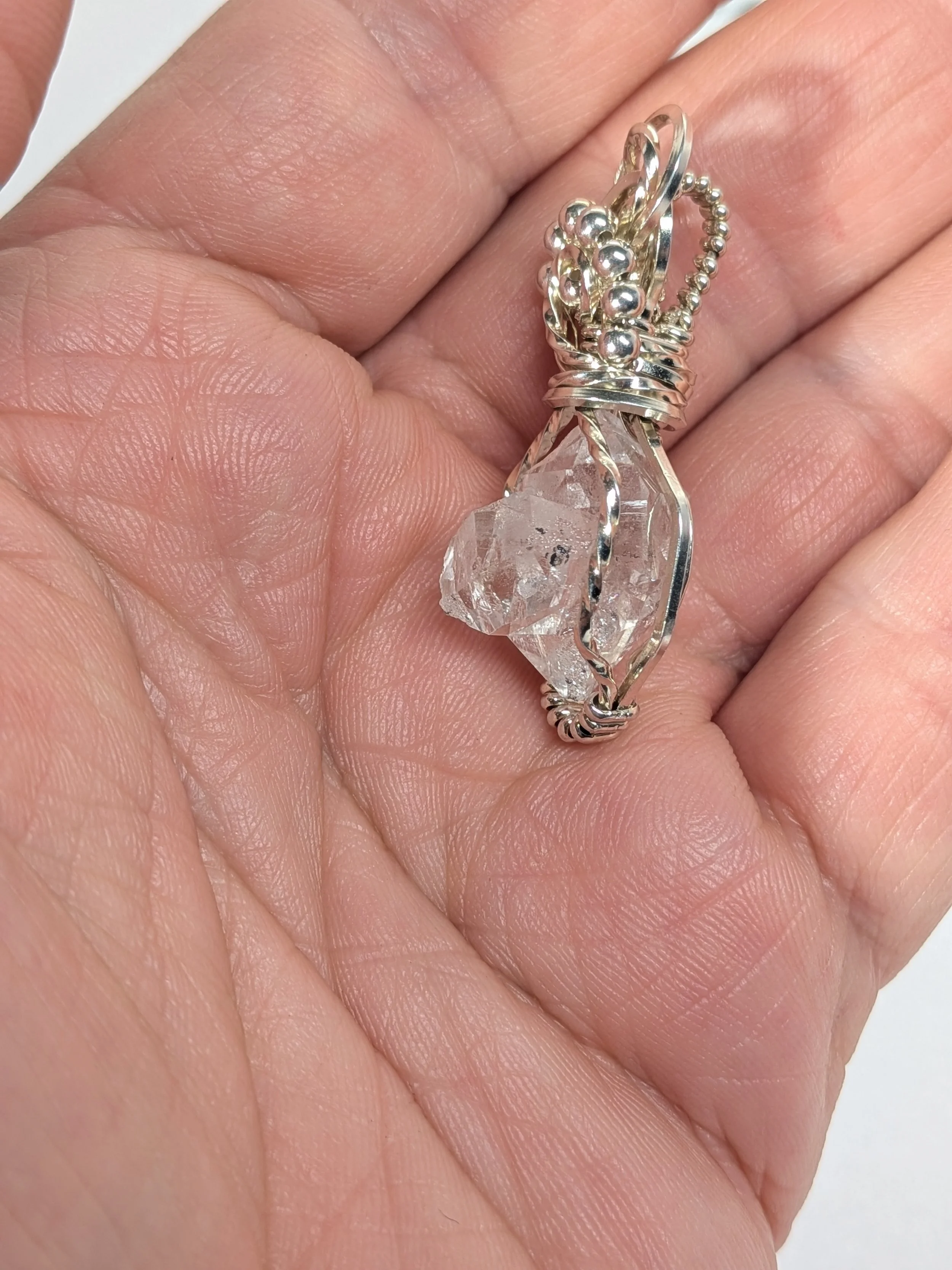 Extra large Herkimer diamond wrapped in antiqued sterling silver wire features an elegant wavy wire bail, with wire twisting and cascading down both sides of the diamond.