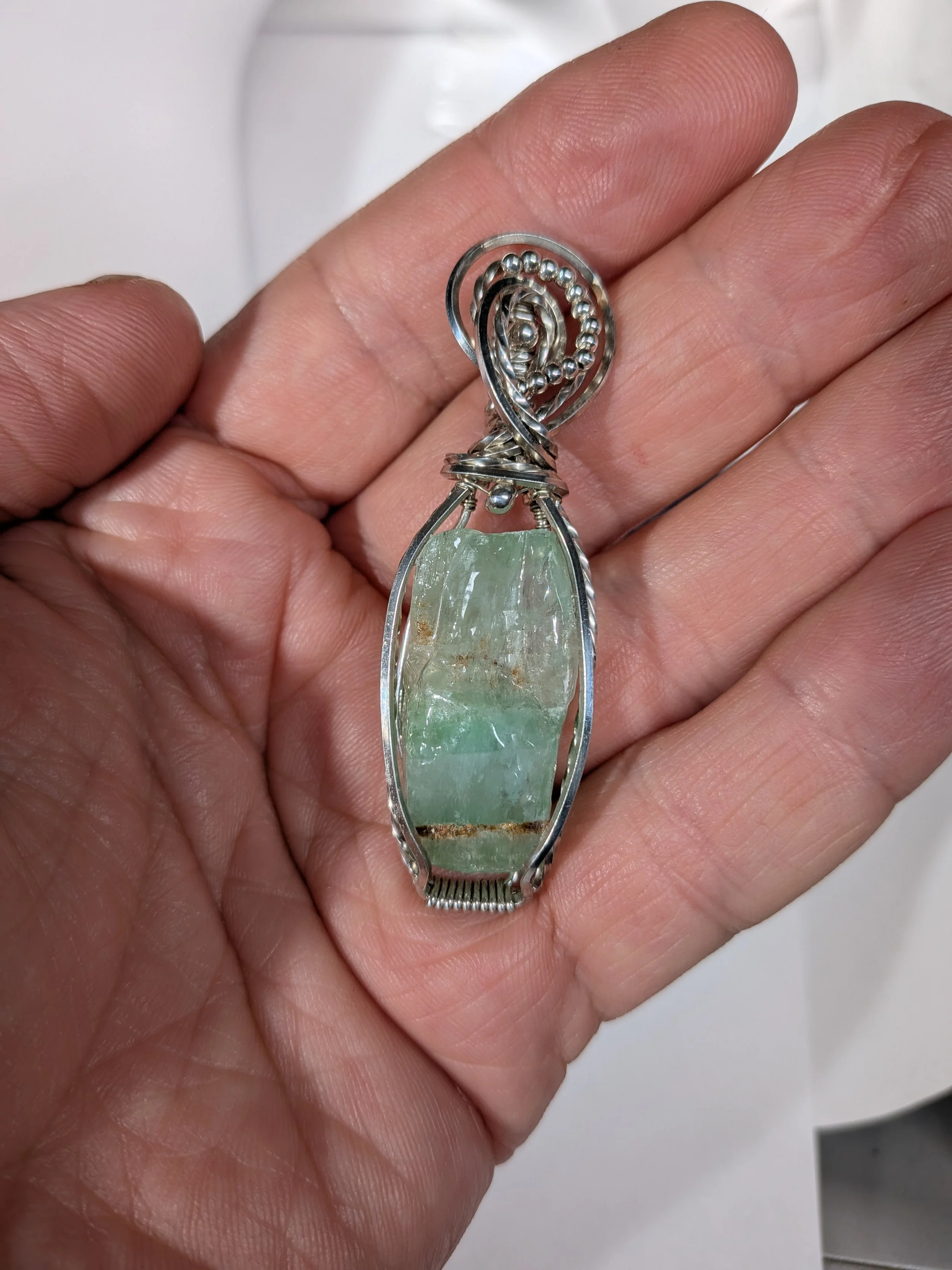 Sterling silver wire wrapped large green calcite gemstone, adorned with small silver beads for an elegant finish.