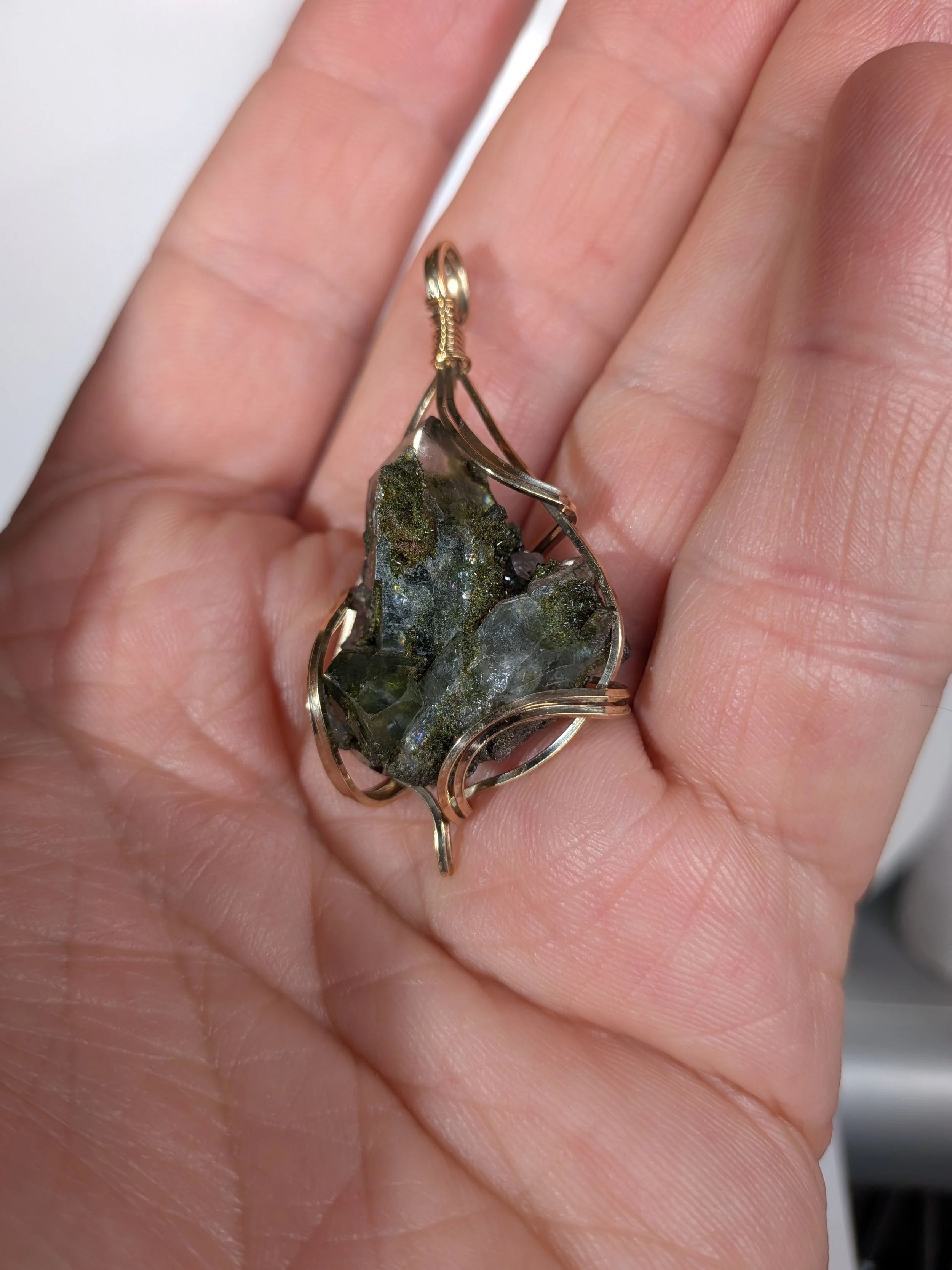 Gorgeous raw epidote, intricately wire-wrapped, beautifully highlighting the stone as the centrepiece.