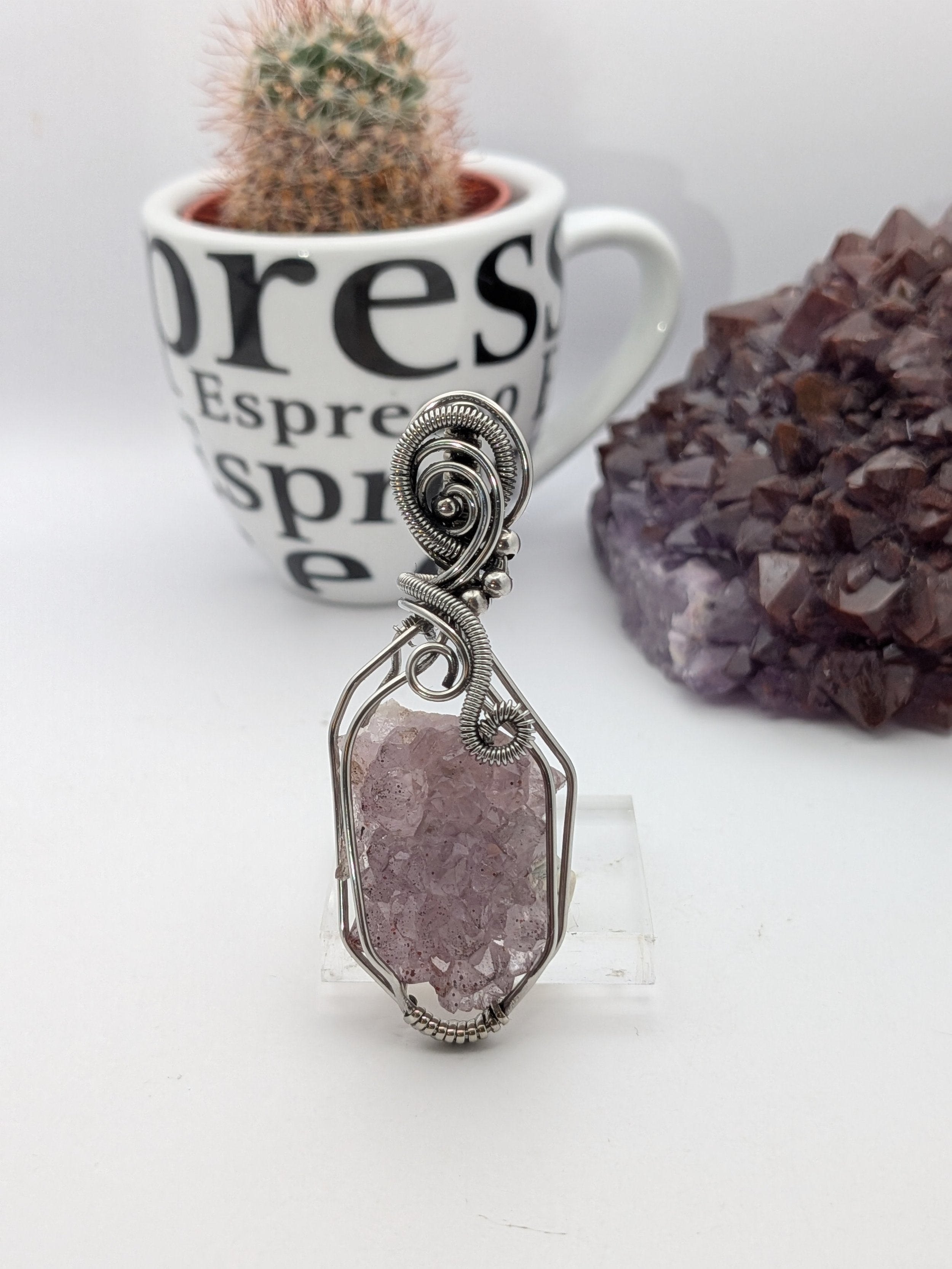 A stunning Thunder Bay amethyst cluster wrapped in stainless wire, elegantly accented with wavy stainless to highlight the amethyst as the focal point.