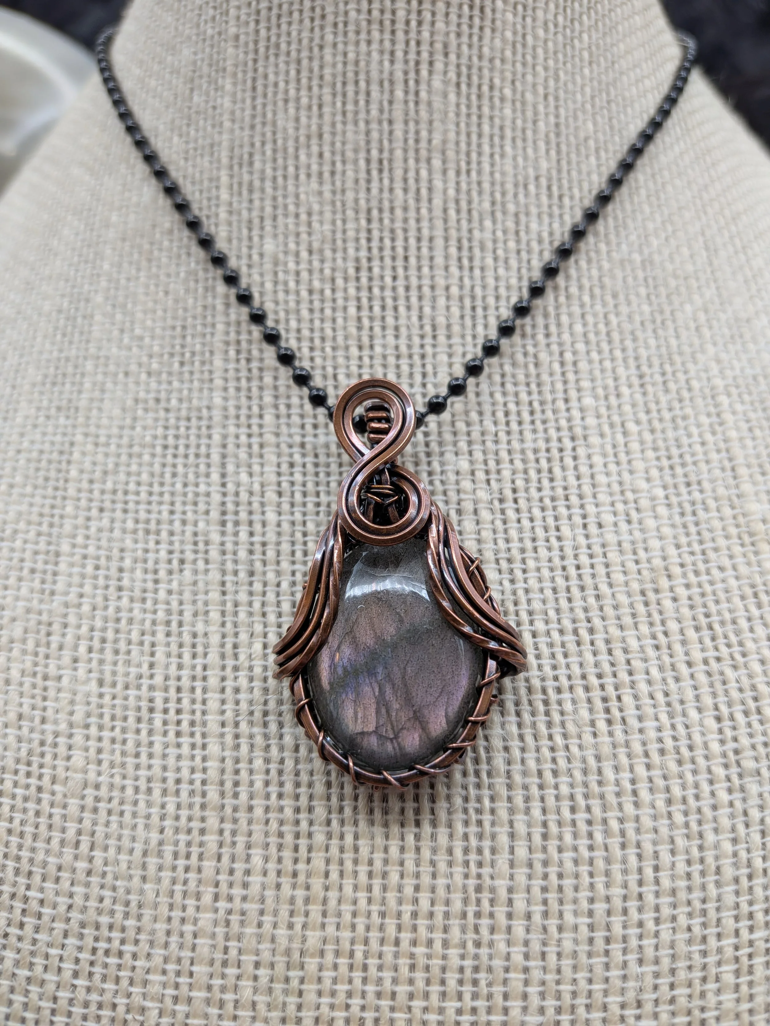 Gorgeous petite teardrop labradorite pendant, intricately wire-wrapped and accented with a heart-style bail, beautifully highlighting the stone as the centerpiece. jpg