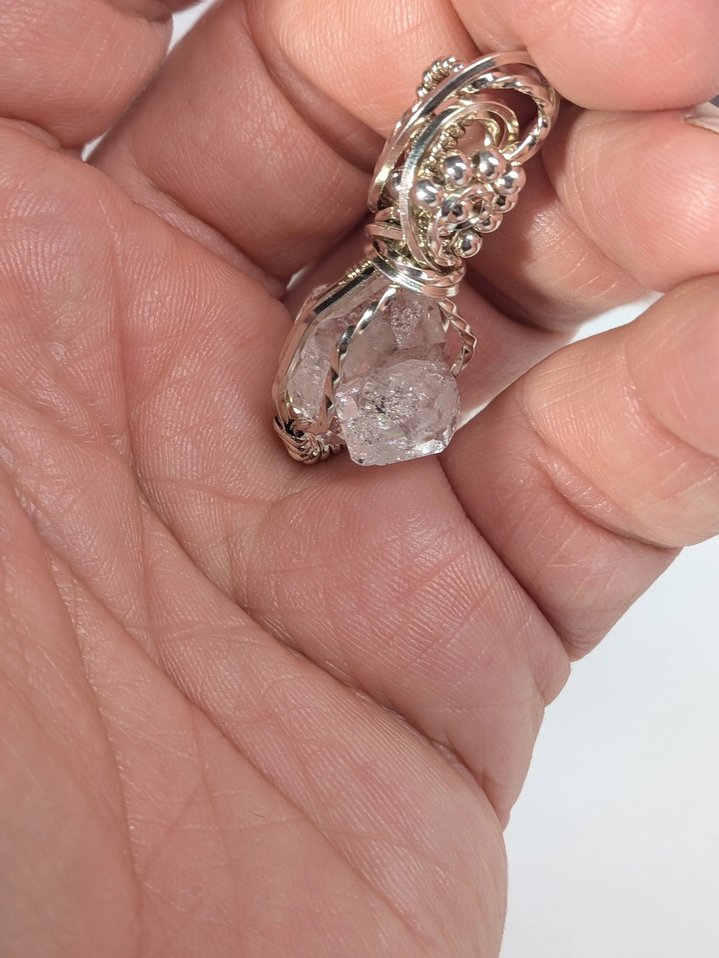 Extra large Herkimer diamond wrapped in antiqued sterling silver wire features an elegant wavy wire bail, with wire twisting and cascading down both sides of the diamond.