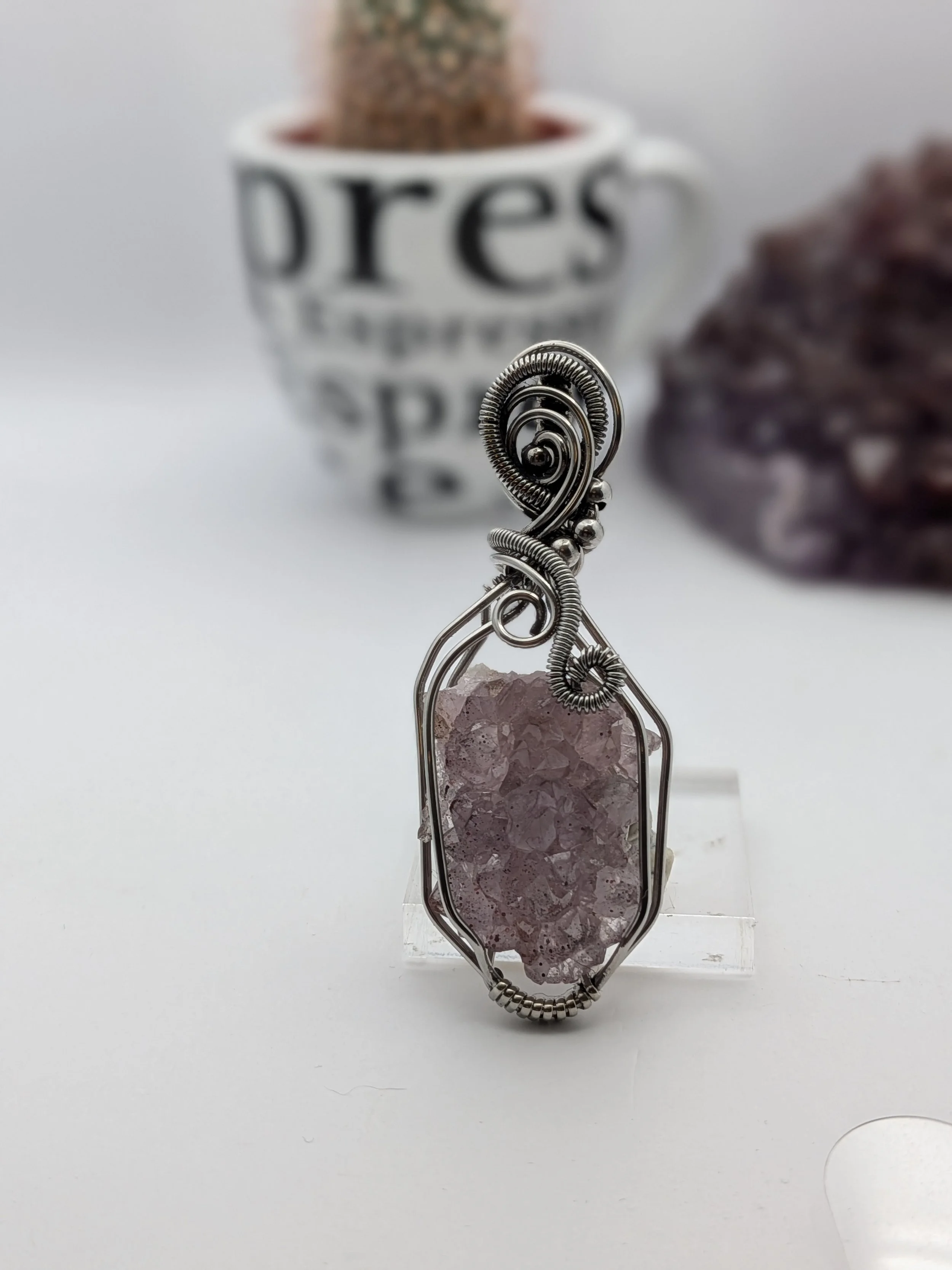 A stunning Thunder Bay amethyst cluster wrapped in stainless wire, elegantly accented with wavy stainless to highlight the amethyst as the focal point.