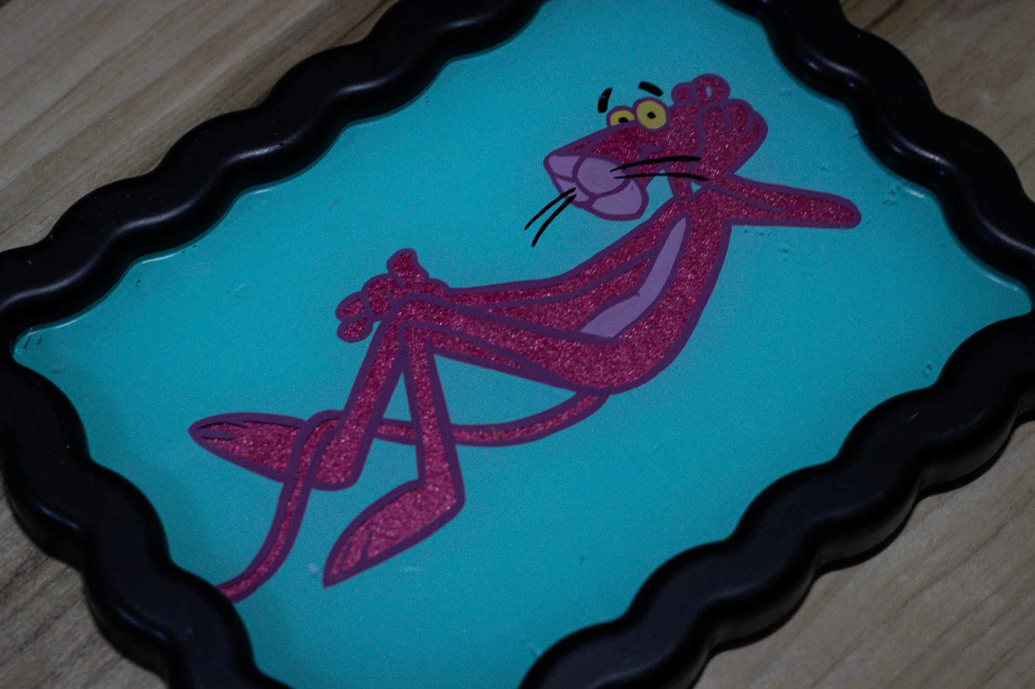 A colorful illustration of the Pink Panther with a wavy black border around the picture.