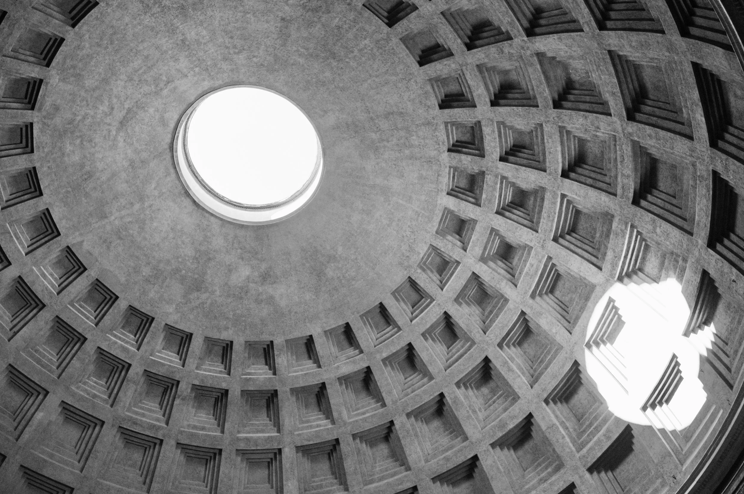 Sunlight streaming through the Pantheon oculus forming bright circle on the interior walls.