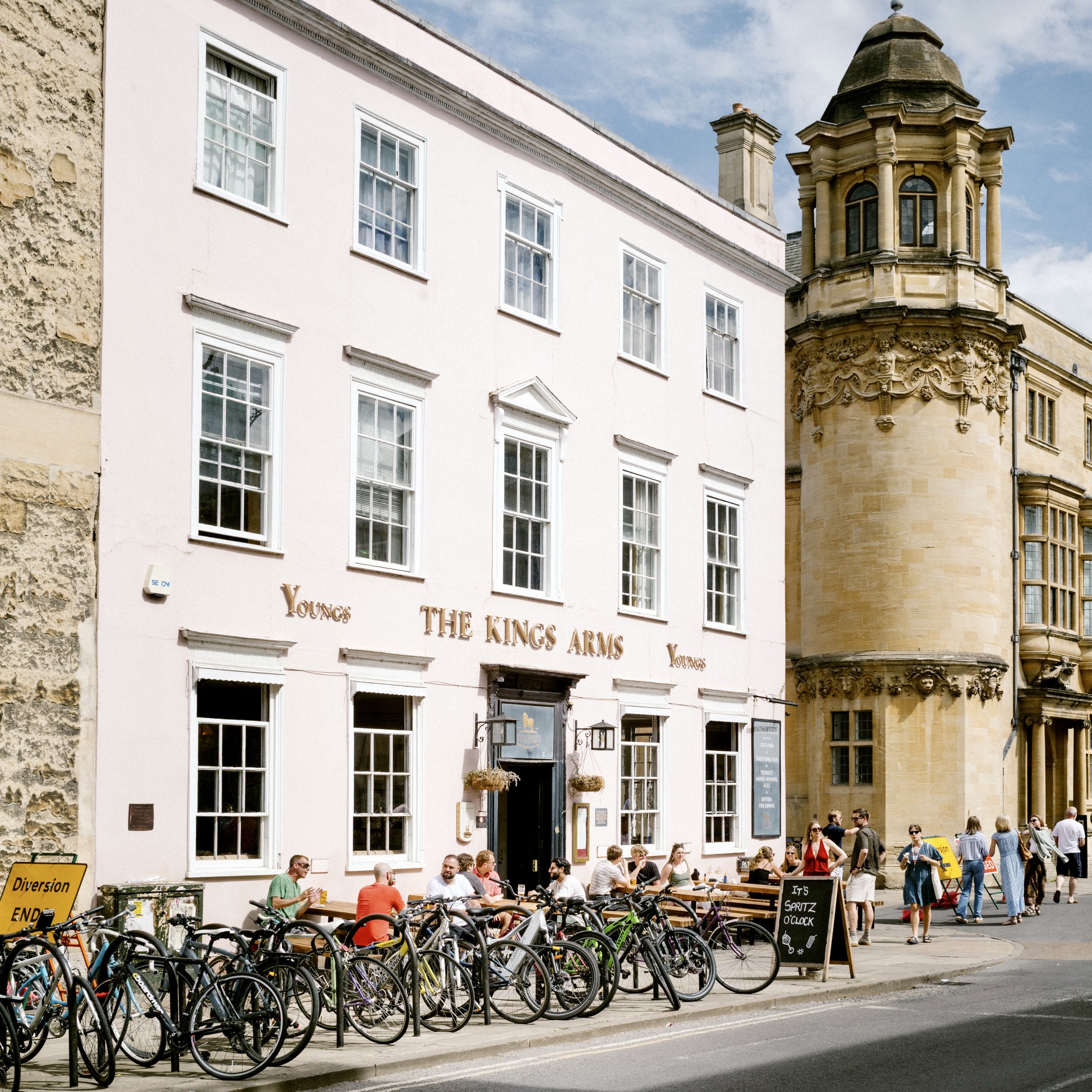 The Kings Arms pub in Oxford with outdoor tables, rows of bicycles and the Bodleian tower behind