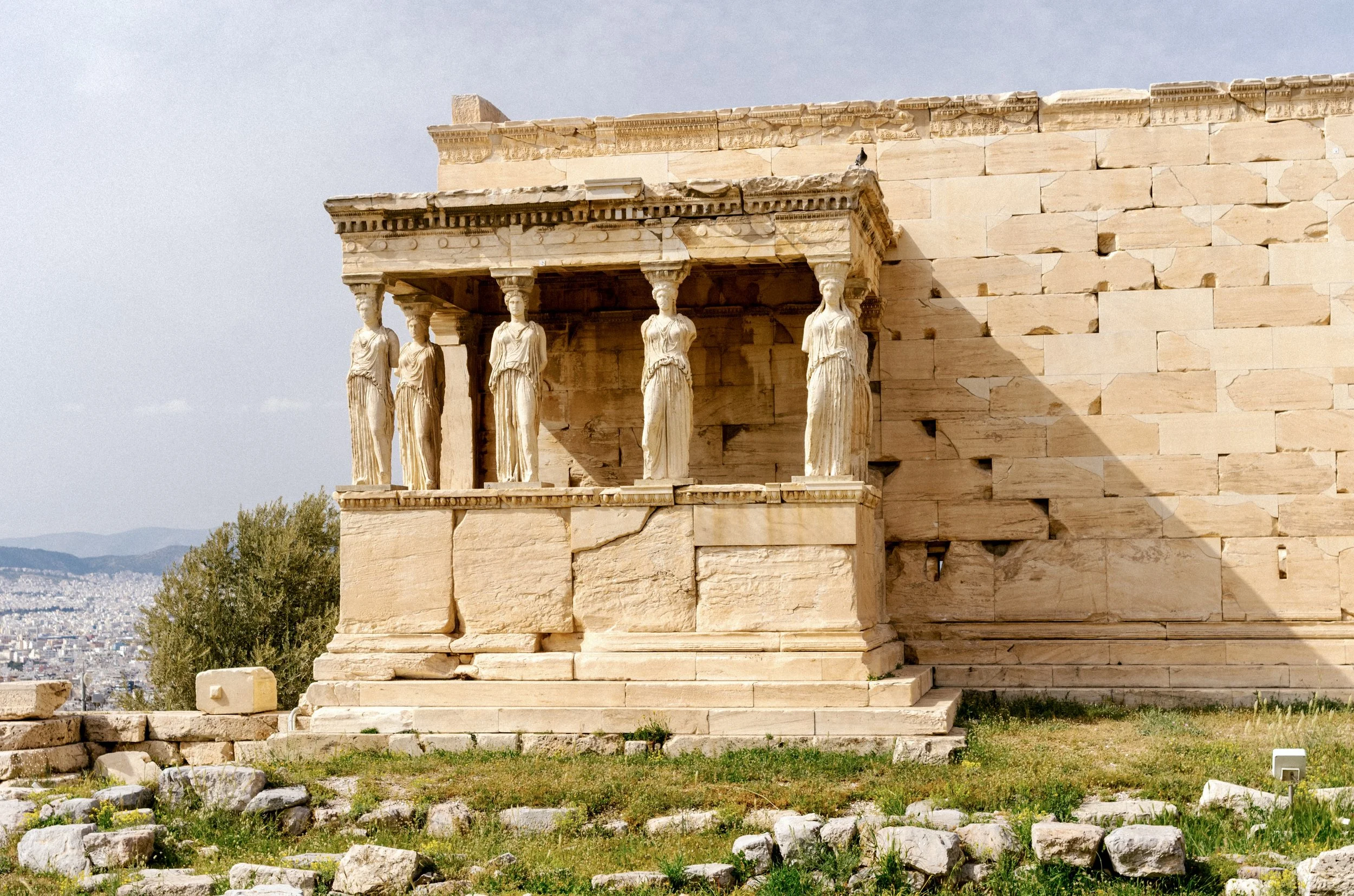 Caryatid porch of the Erechtheion on the Acropolis of Athens showing female column figures against blue sky