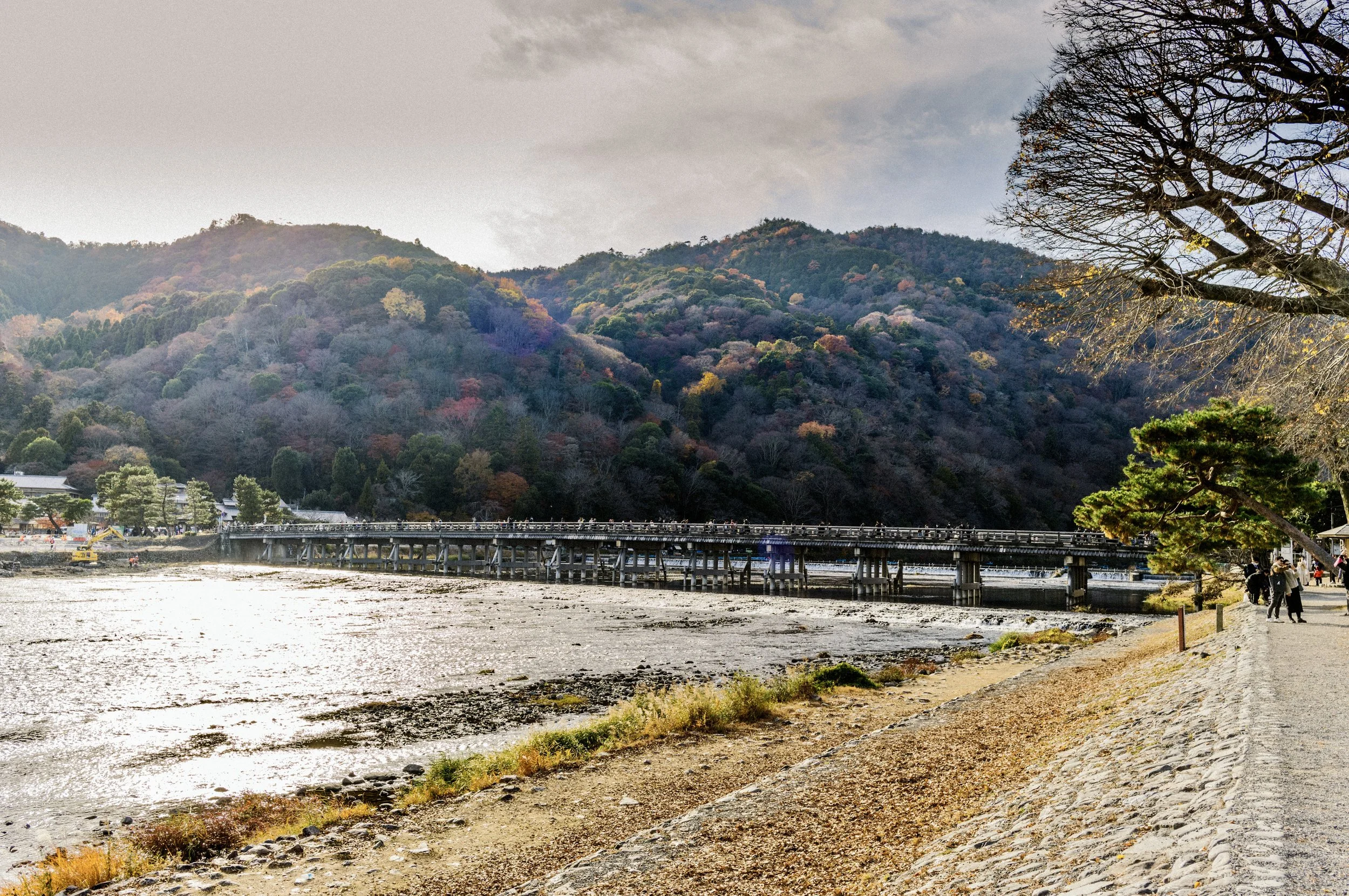 Togetsukyo Bridge spanning the Katsura River in Arashiyama with forested mountains behind it.