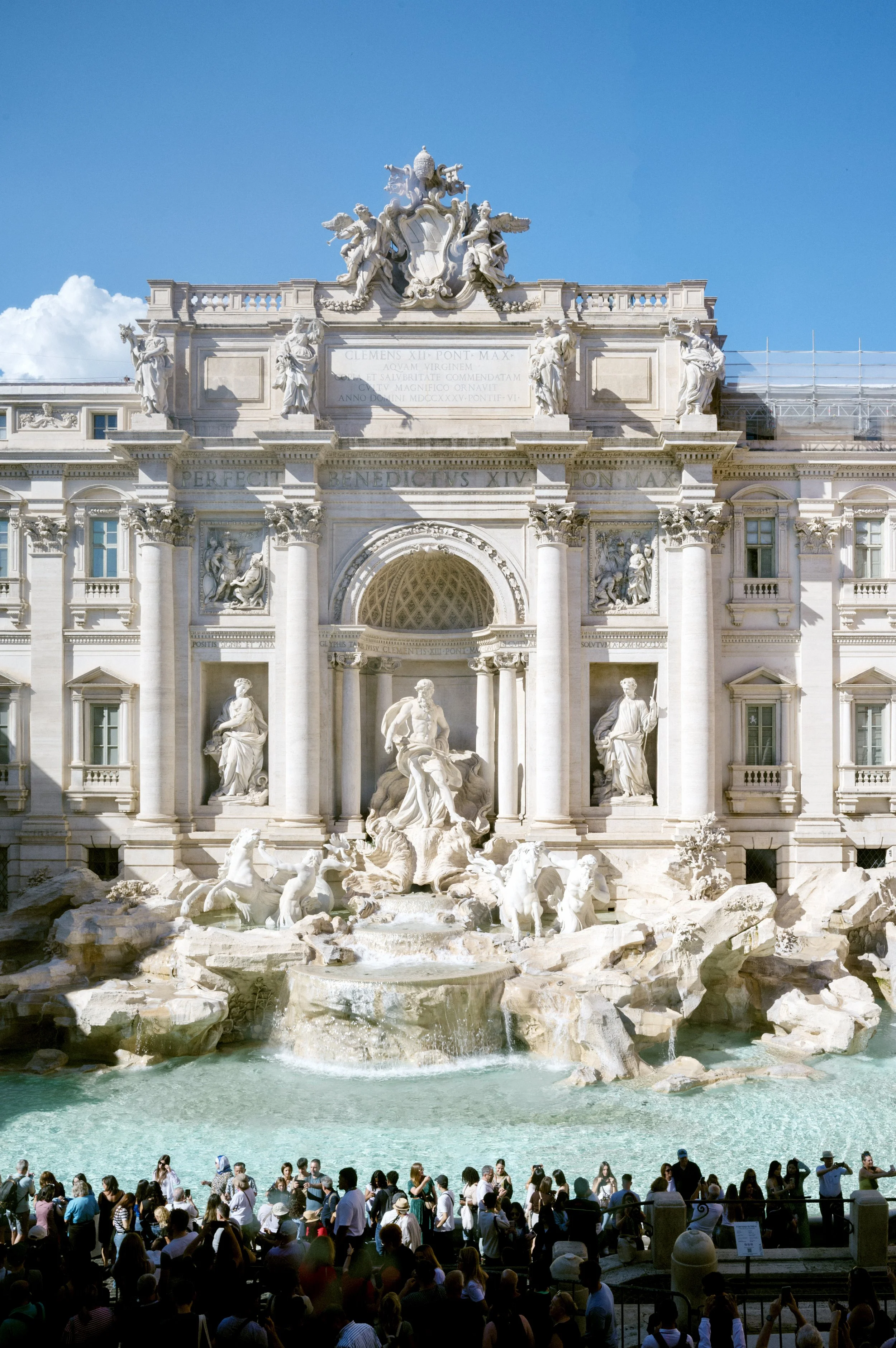View of Trevi Fountain from first-floor window of United Colors of Benetton store offering elevated perspective.
