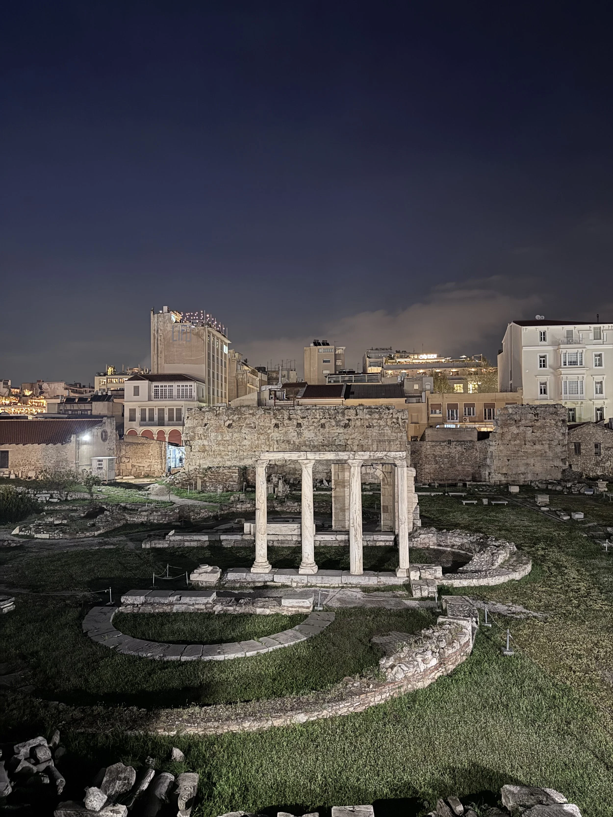 Hadrian's Library illuminated at night in Athens Greece with ancient columns lit against dark sky