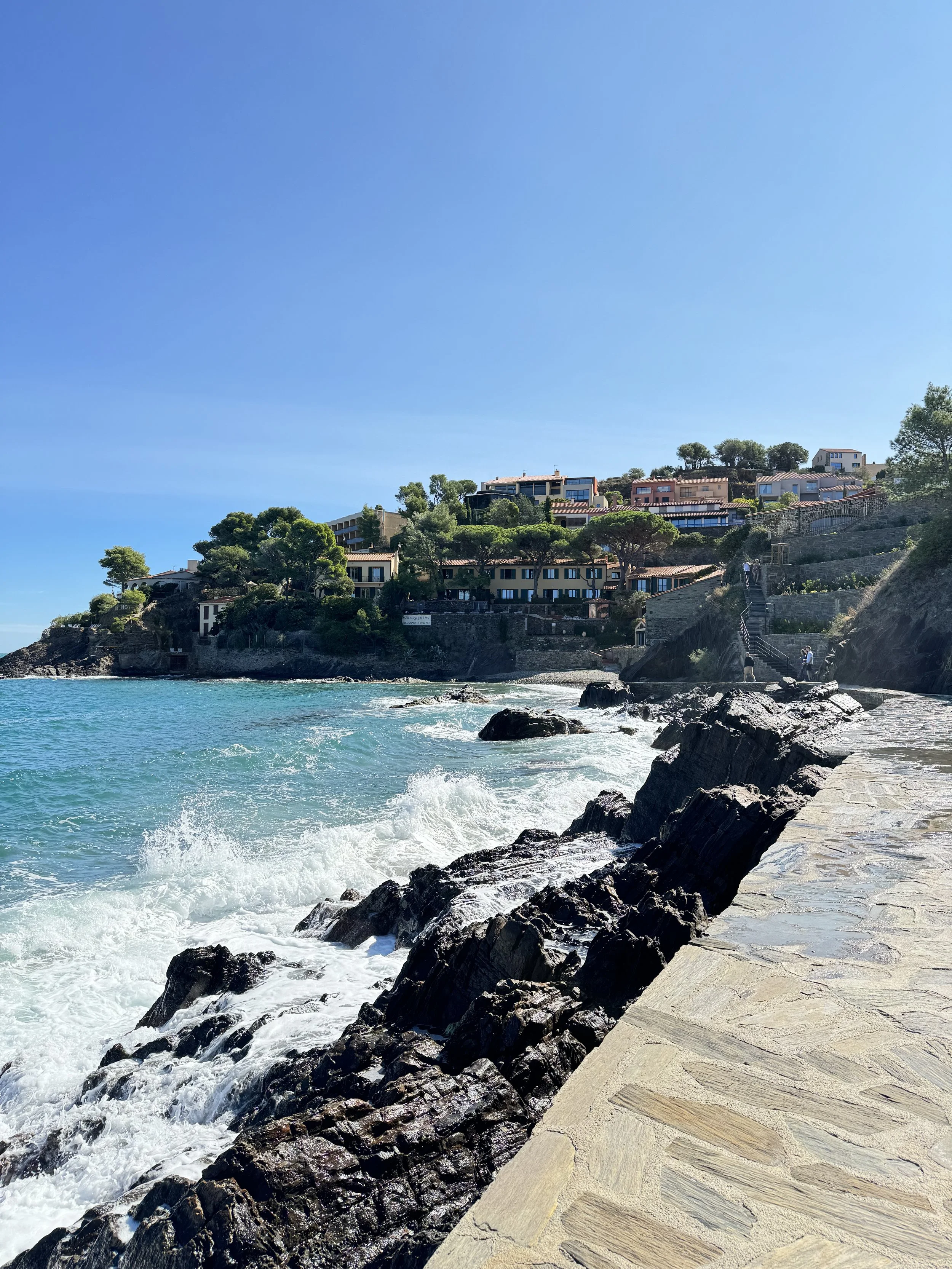 Pastel houses along the bay of Ansa de la Baleta – dramatic seaside view with Mediterranean backdrop
