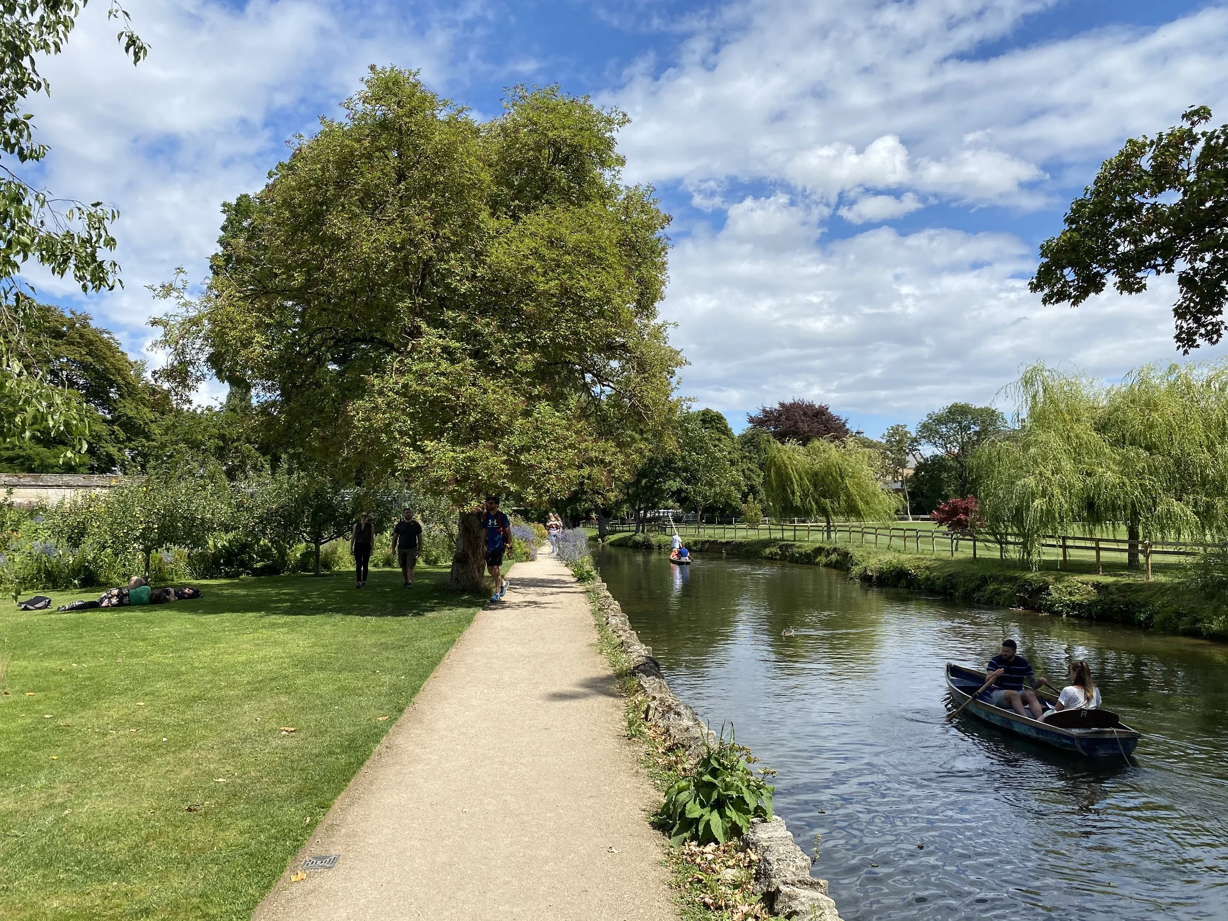 Riverside path along the River Cherwell in Oxford with a rowing boat and willow trees