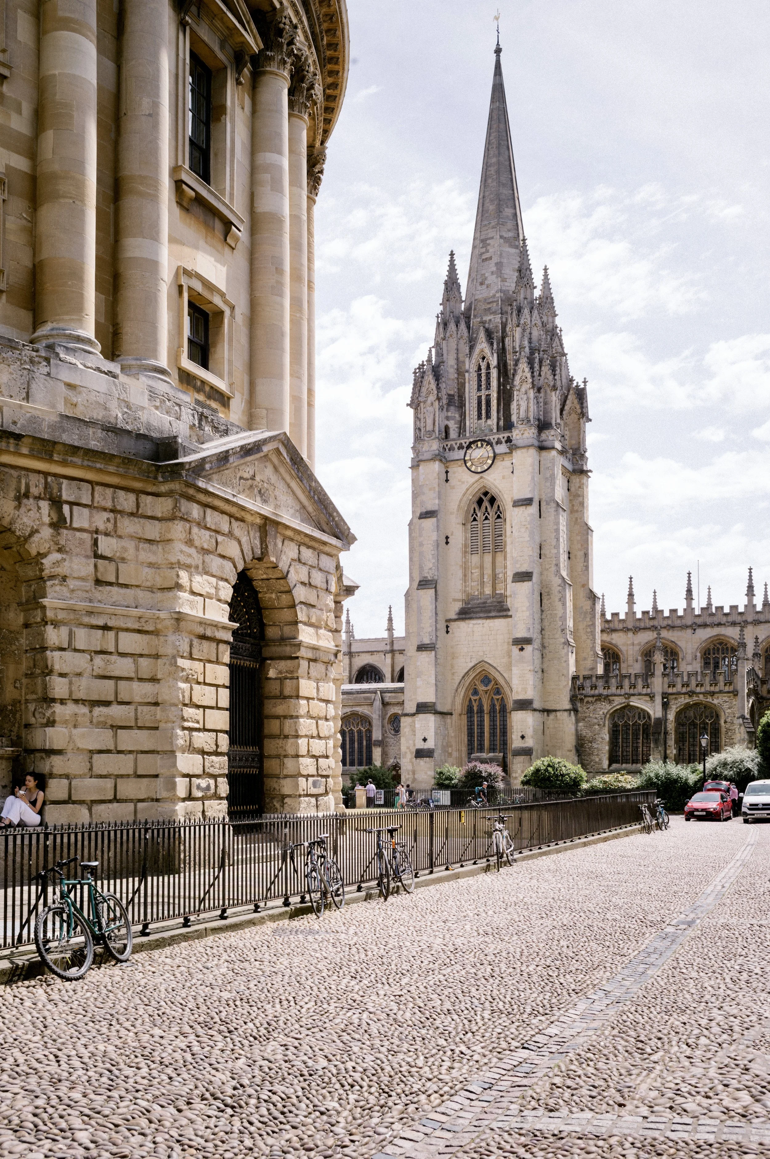 Radcliffe Square cobbles in Oxford with the spire of St Mary the Virgin and bicycles on the railings
