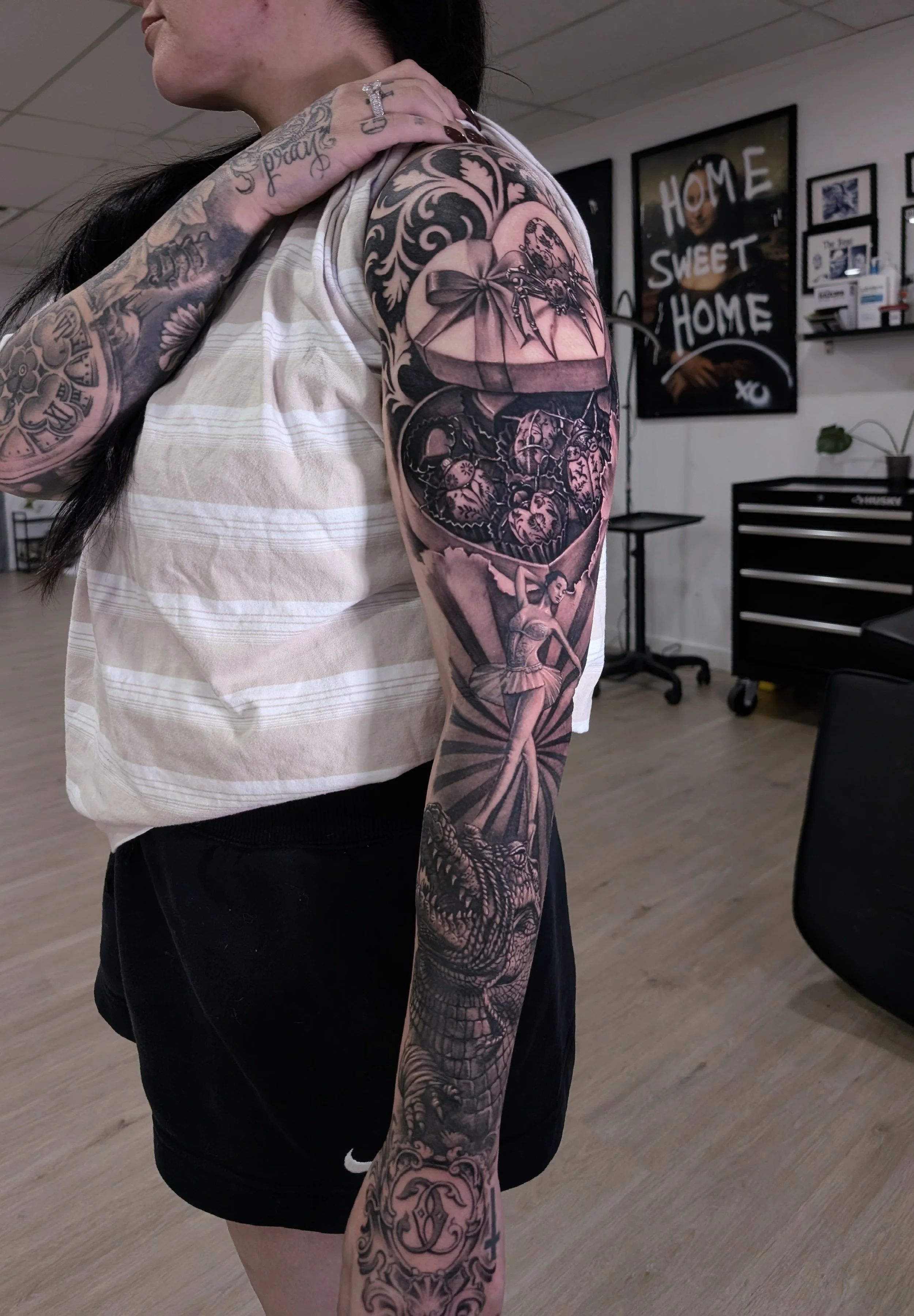 black and grey realism sleeve with a circus theme including an alligator, a ballerina and a box of chocolates filled with ceramic bugs