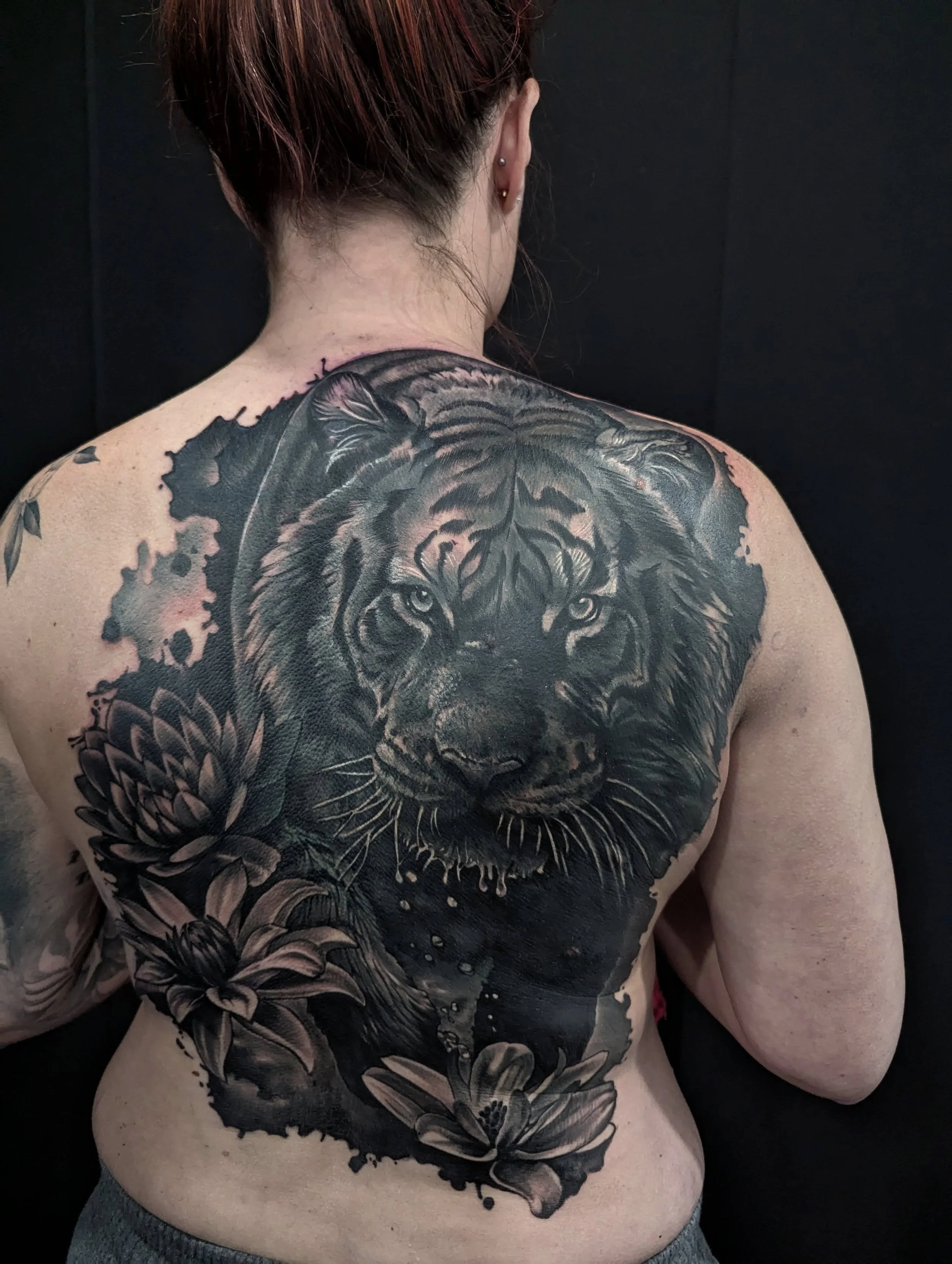 coverup tattoo showing a tiger and lillies