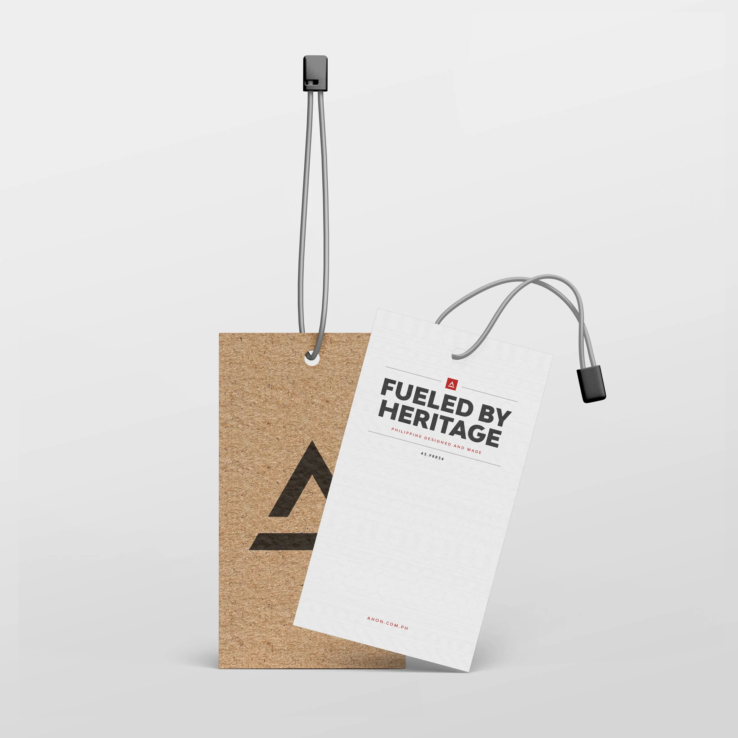 Ahon apparel hang tags with a black logo on kraft paper and Fueled by Heritage lettering on a white tag.