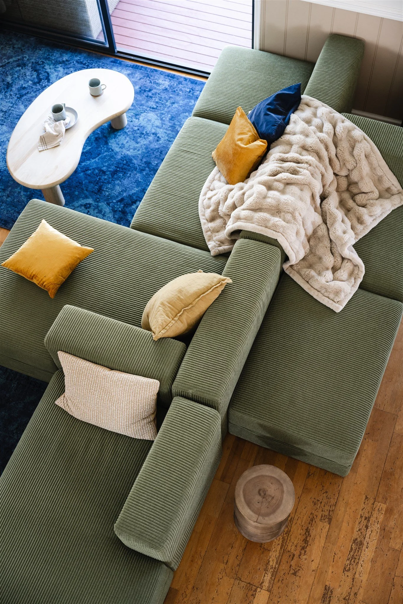 The River House Pinjarra - Boutique Riverside short stay accommodation in Pinjarra, near Dwellingup, Western Australia. A cosy interior setting with the large modular lounge  styled with cushions and a throw rug.