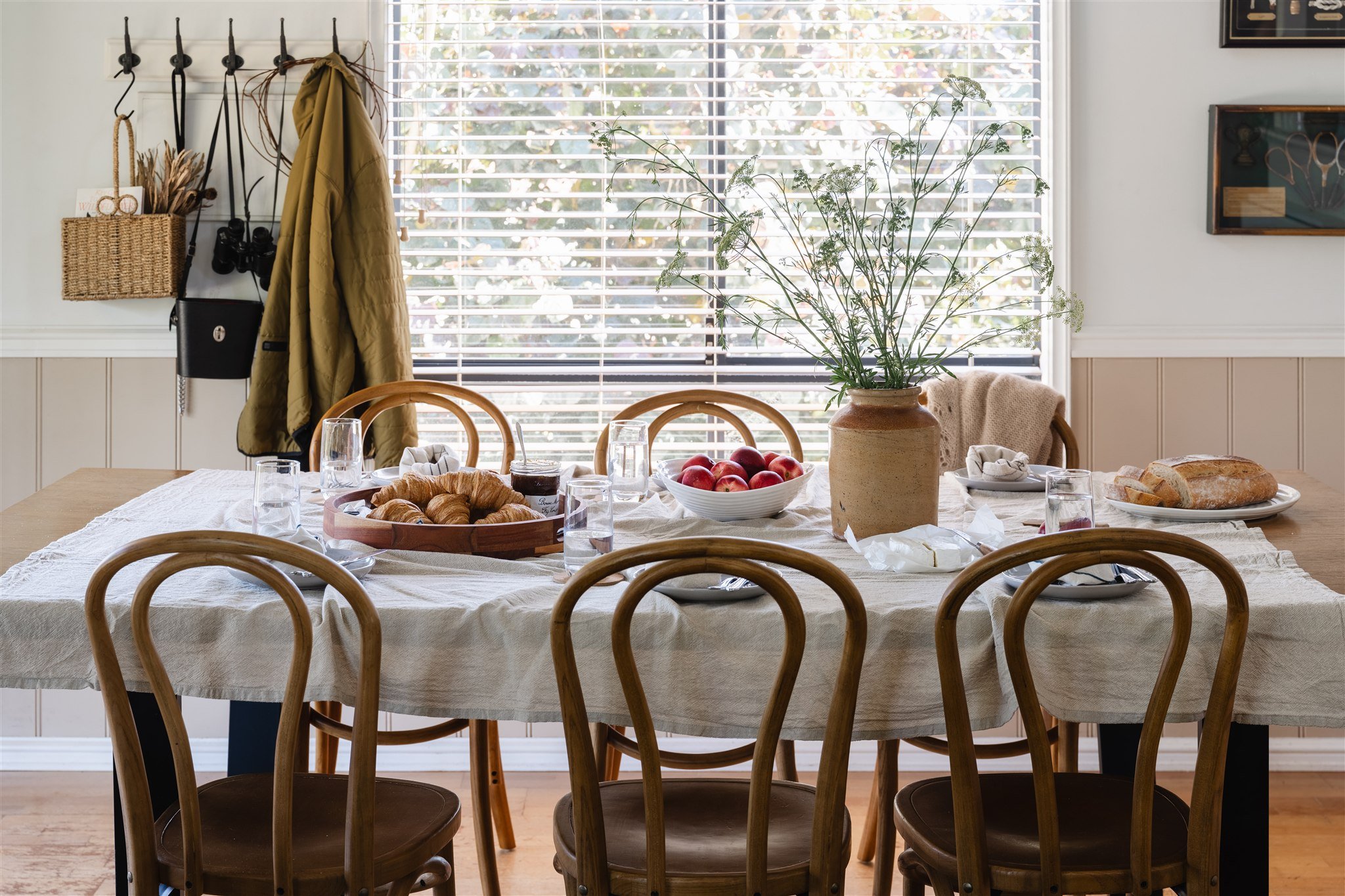 The River House Pinjarra - Boutique Riverside short stay accommodation in Pinjarra, near Dwellingup, Western Australia. A styled dining setting featuring a large solid timber table and chairs and  a window in the background. 