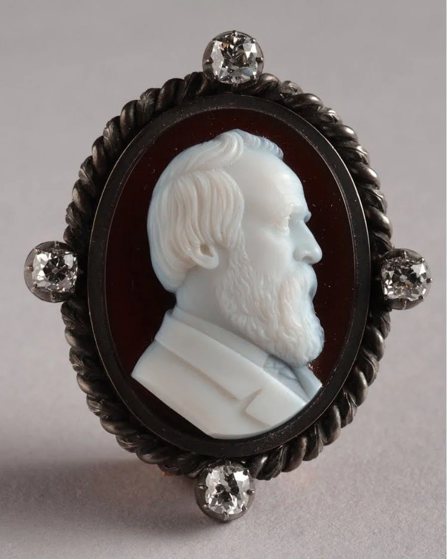 This brooch was a silver wedding anniversary gift from her husband, President Rutherford B. Hayes, to Lucy Hayes. The anniversary was celebrated in the White House on December 30, 1877.

The milky quartz cameo was made and signed &quot;L. Zoellner 83