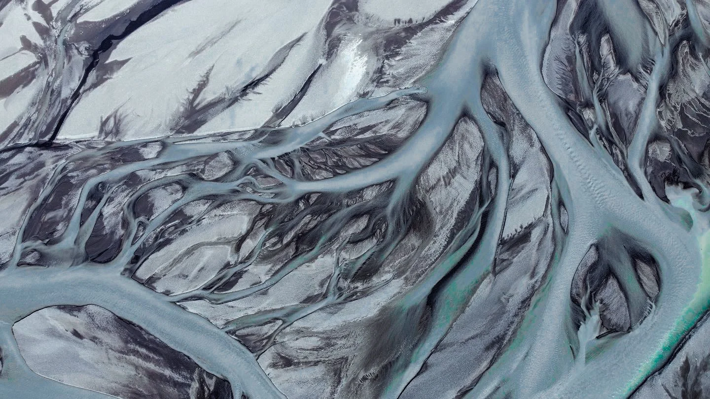 Aerial view of a river delta with channels and wetlands, showing intricate blue-green waterways and dark land masses.