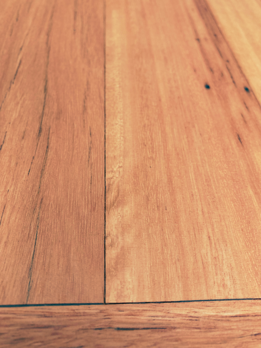 Close-up photo of a wooden surface of casket, showing wood grain and natural color.