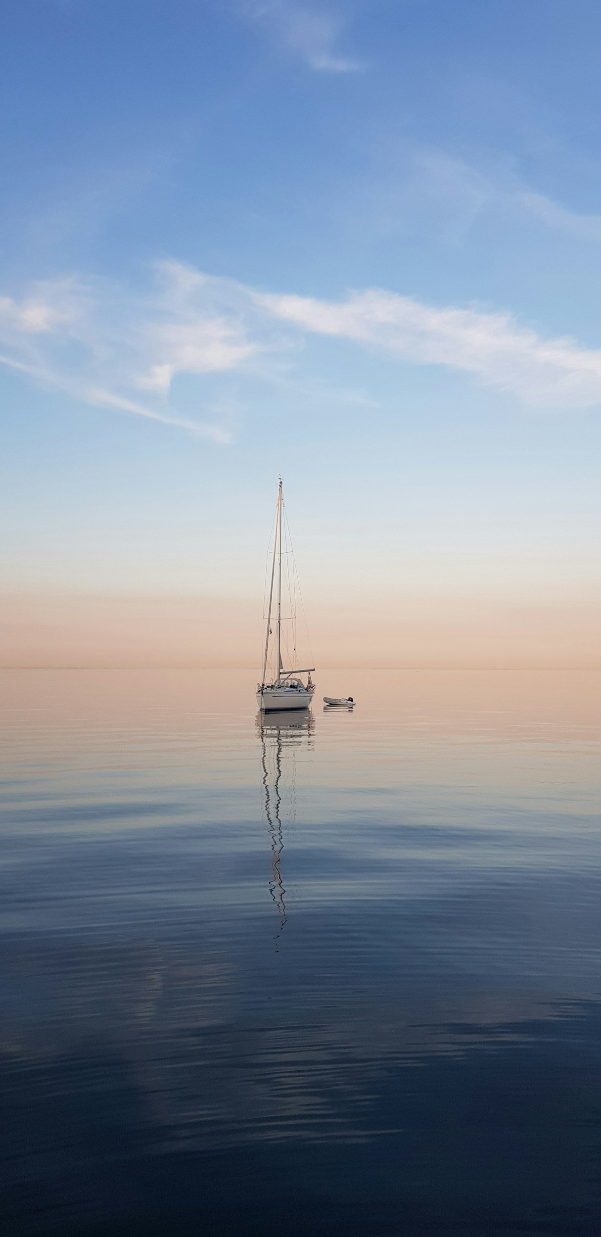 Sailboat floating on calm water with a clear sky