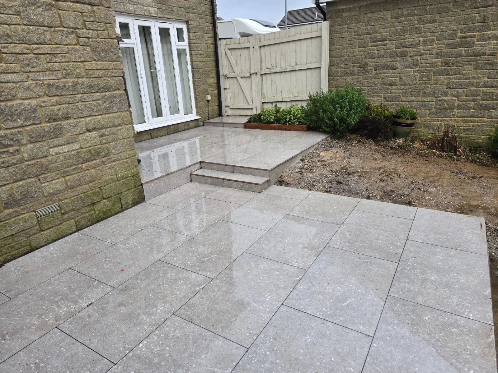 Beautiful finished patio, freshly installed into a garden in Cornwall by Rashleigh & Son. Grey porcelain patio.