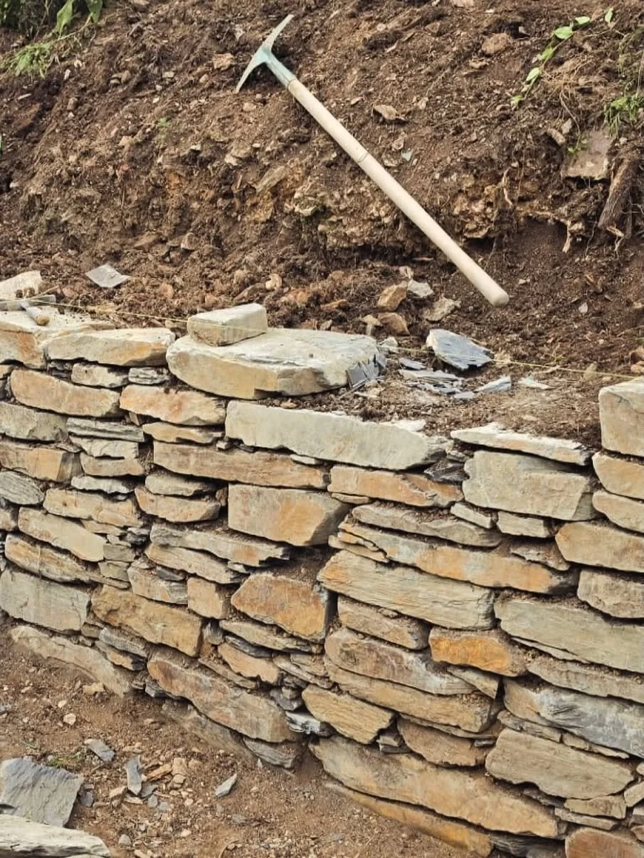 Traditional dry stone wall being built during a landscaping project in Cornwall