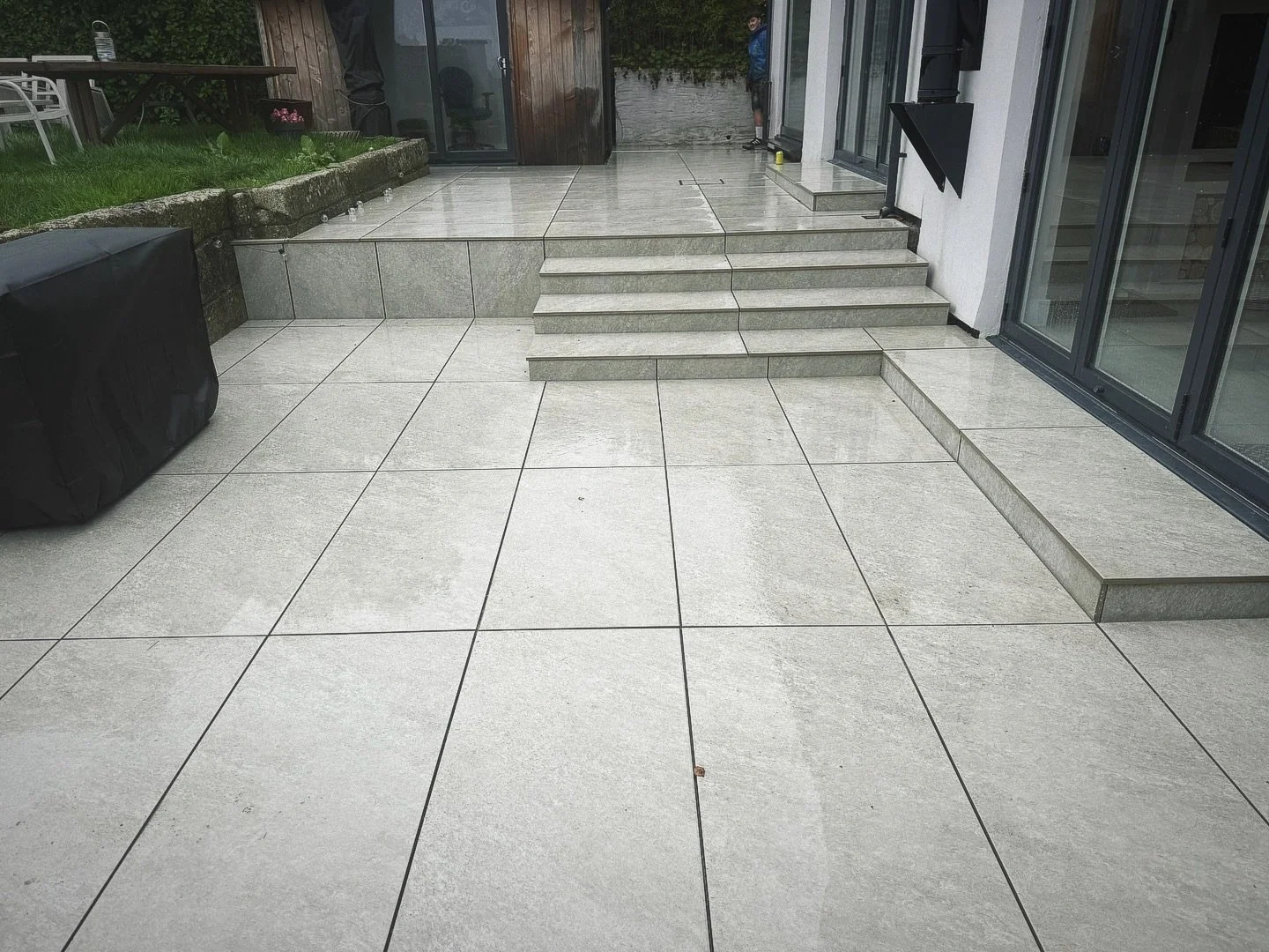 Porcelain patio installation with garden steps and raised levels by landscape gardener in Falmouth Cornwall