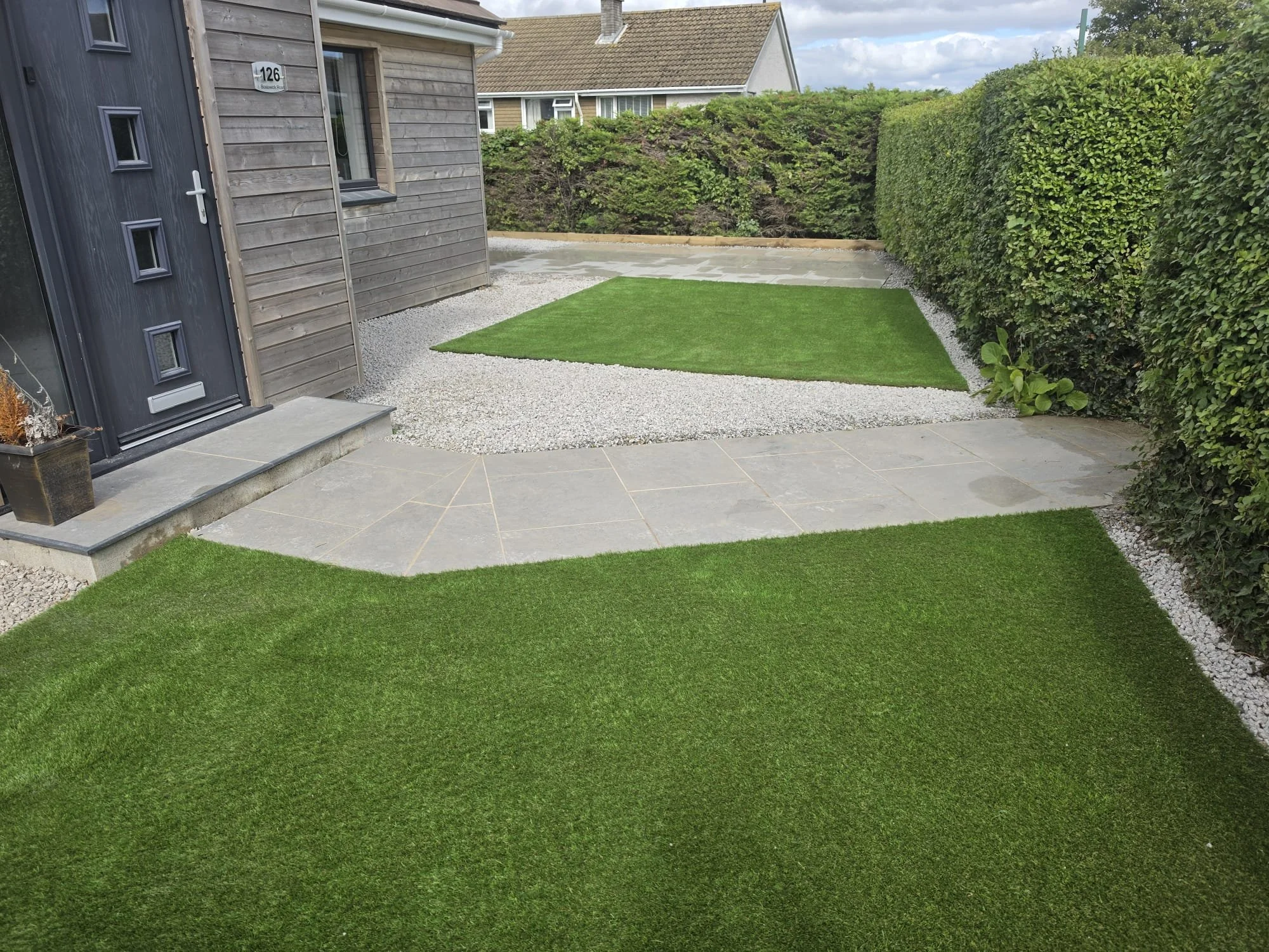 Landscaped garden in Cornwall with artificial lawn, paved paths and gravel borders