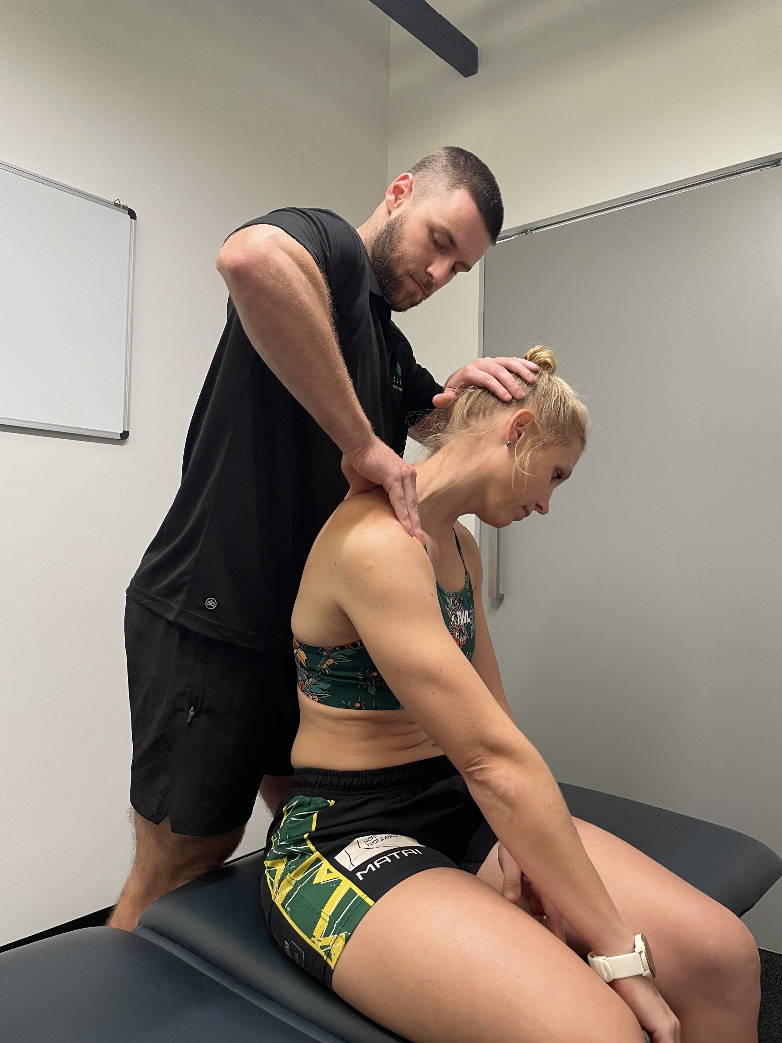 Remedial massage therapist treating neck tension