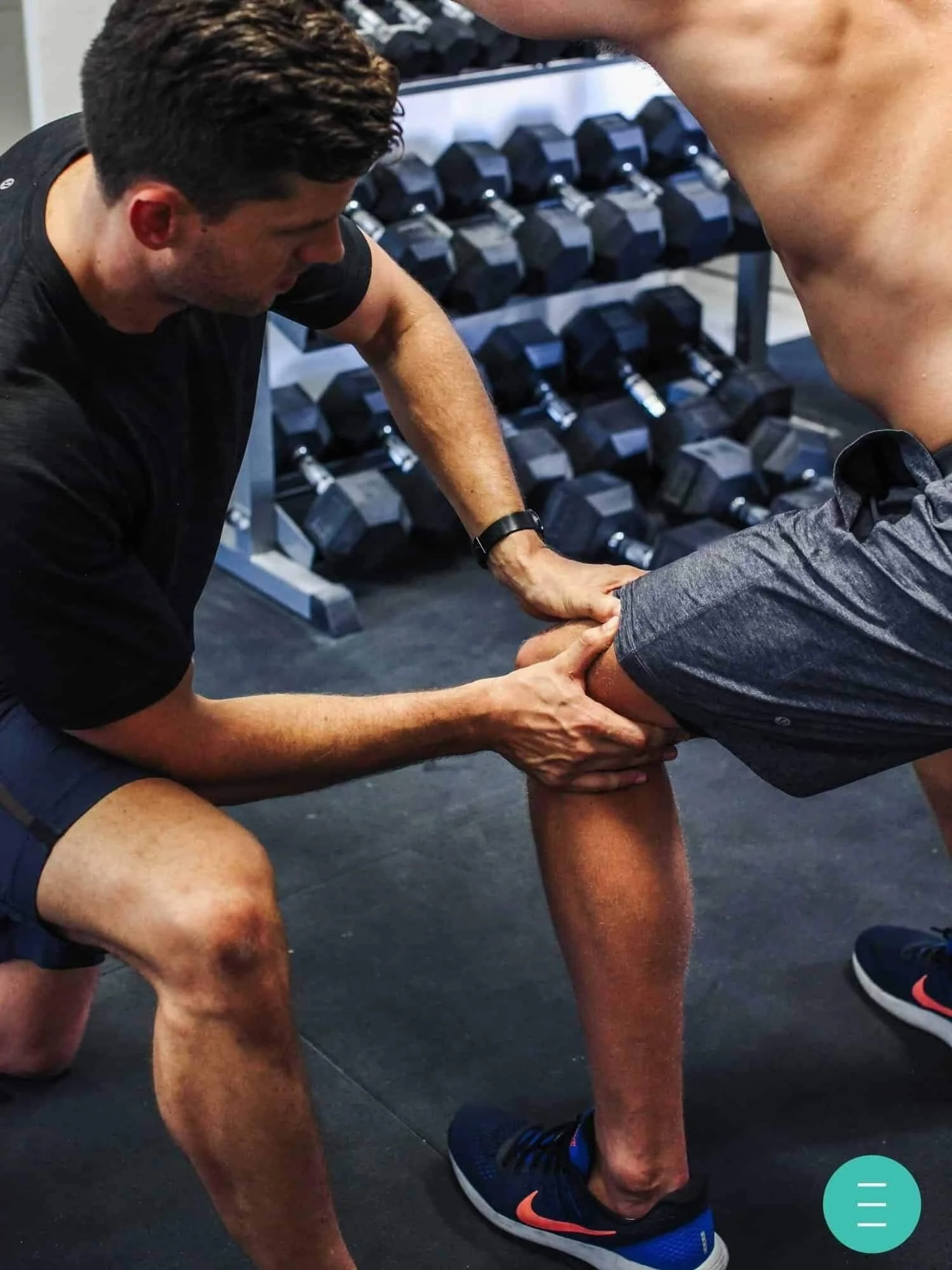 Physiotherapist assisting with knee rehabilitation exercise in a gym at Elite Health Performance