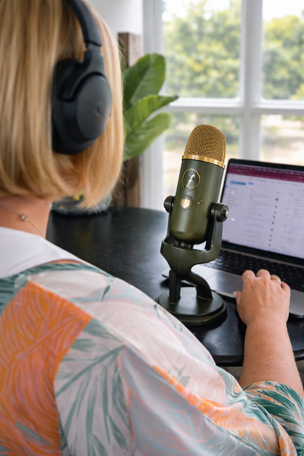 Sam DiNicola recording a guest podcast at a desk with headphones on and a microphone, captured from behind to show a real behind-the-scenes setup for small business education and speaking.
