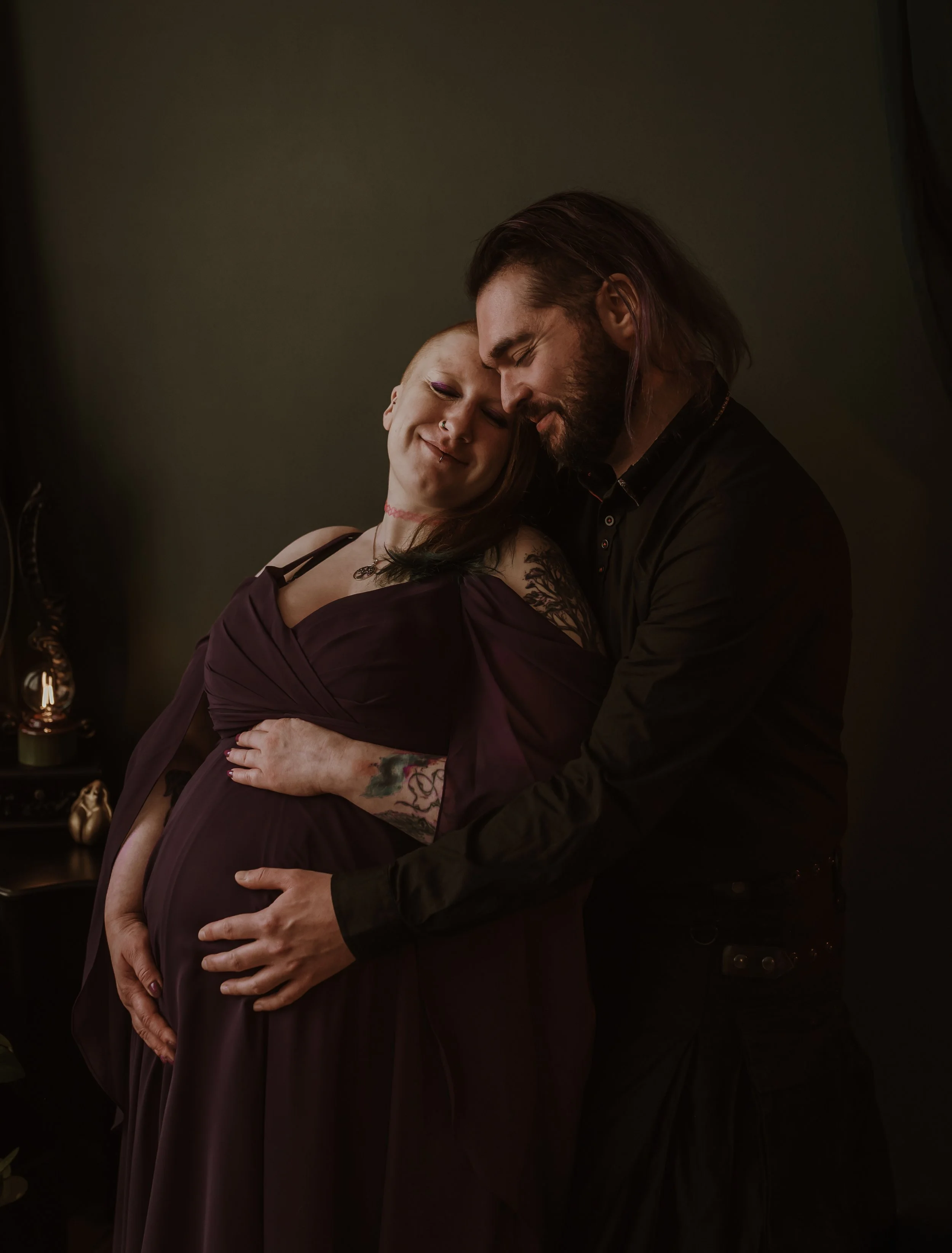 Pregnant woman and partner sharing a tender moment during a studio maternity session in Glasgow with Marieke Captures Birth, client Cuan