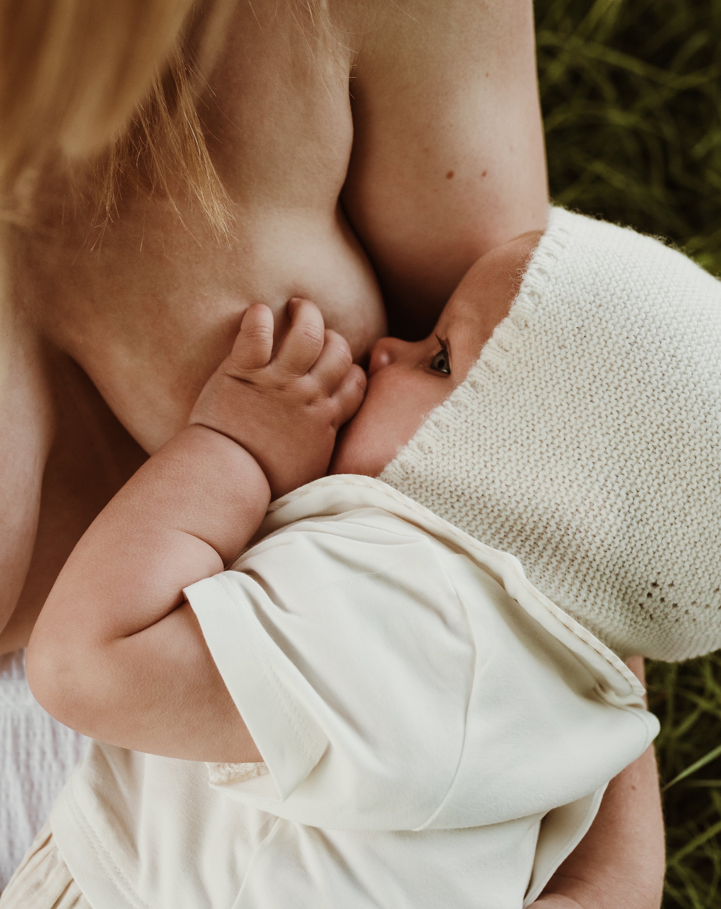 Close up of mother nursing her baby in a cream knit wrap during a nursing photography session with Glasgow photographer Marieke Captures Birth