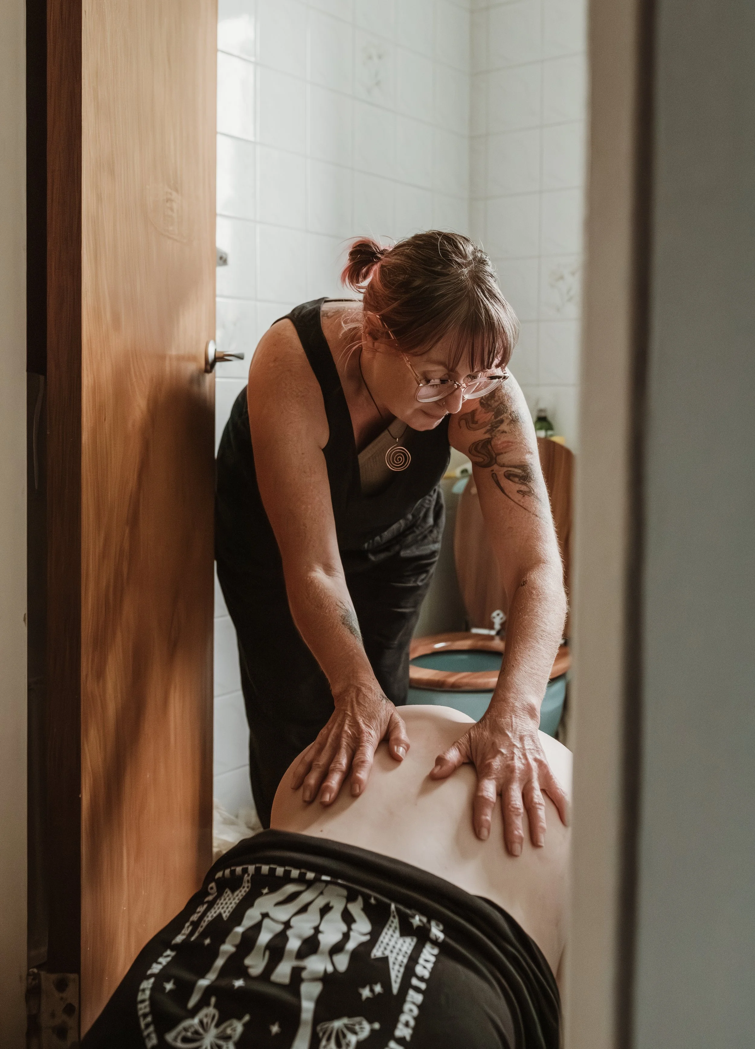 Doula working at a home birth in Scotland, leaning in to support a mother during labour
