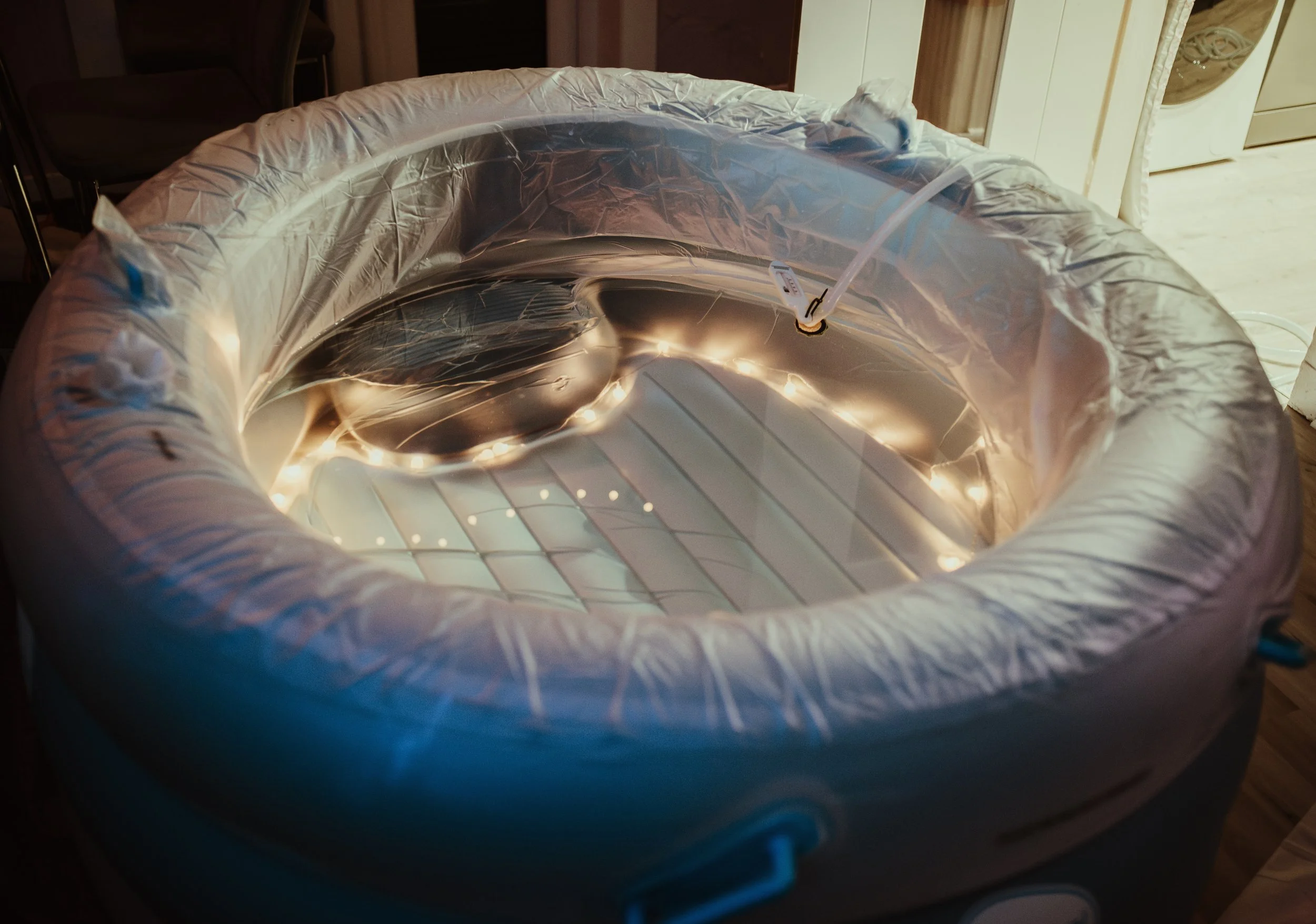 Birth pool filled with warm water and surrounded by soft fairy lights, carefully prepared for a home water birth in Largs Scotland