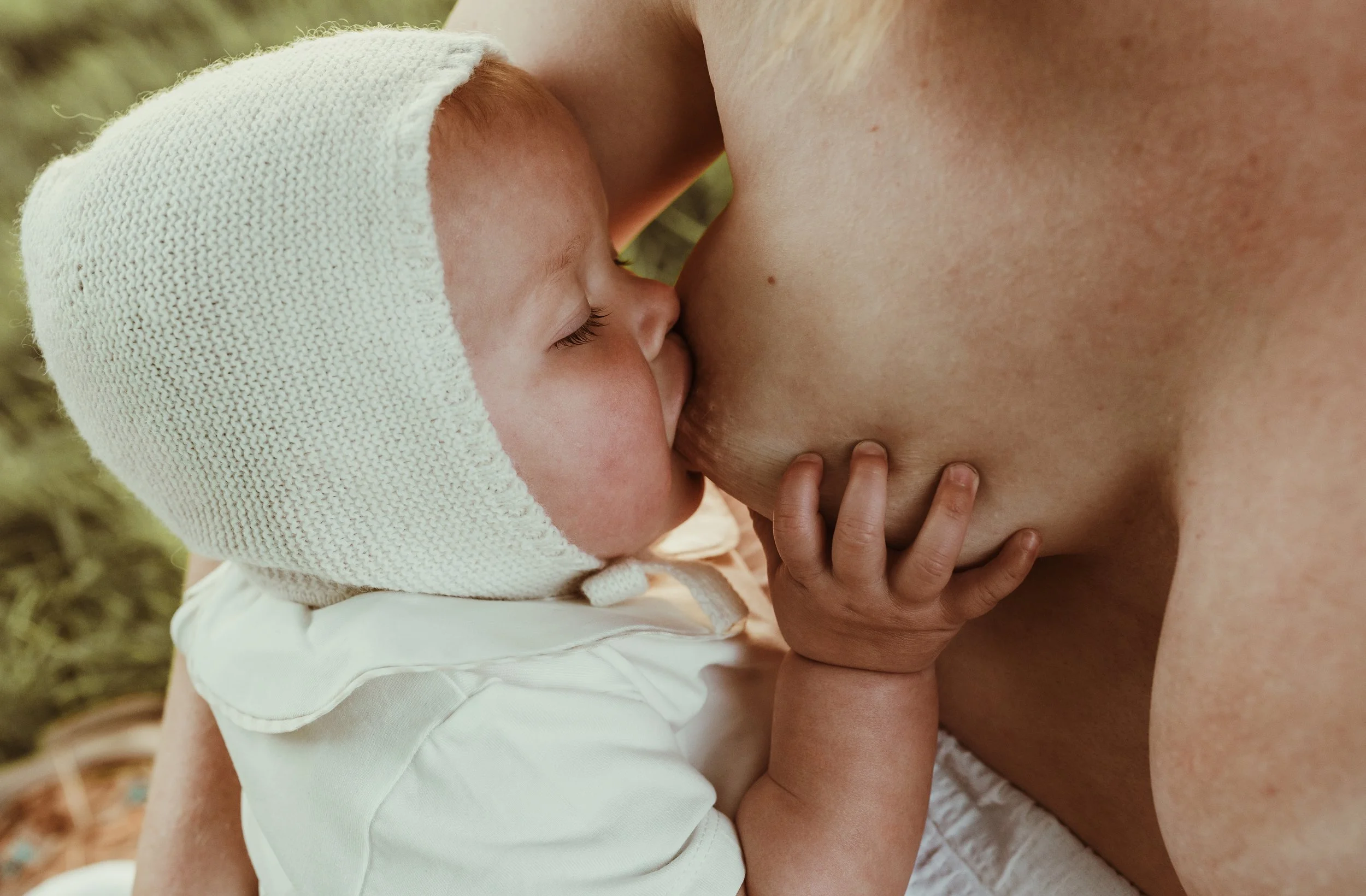Close up of baby breastfeeding wrapped in a soft white knit during a nursing photography session with Glasgow photographer Marieke Captures Birth