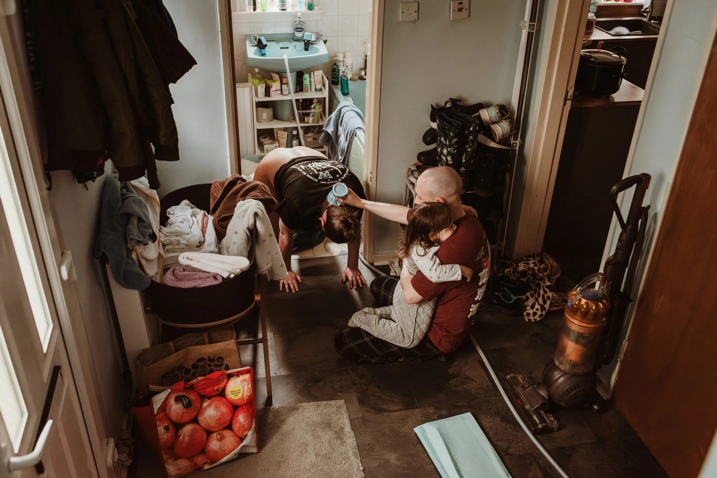 Partner helping labouring woman in bathroom during home birth, Glasgow — documentary birth photography by Marieke Captures Birth