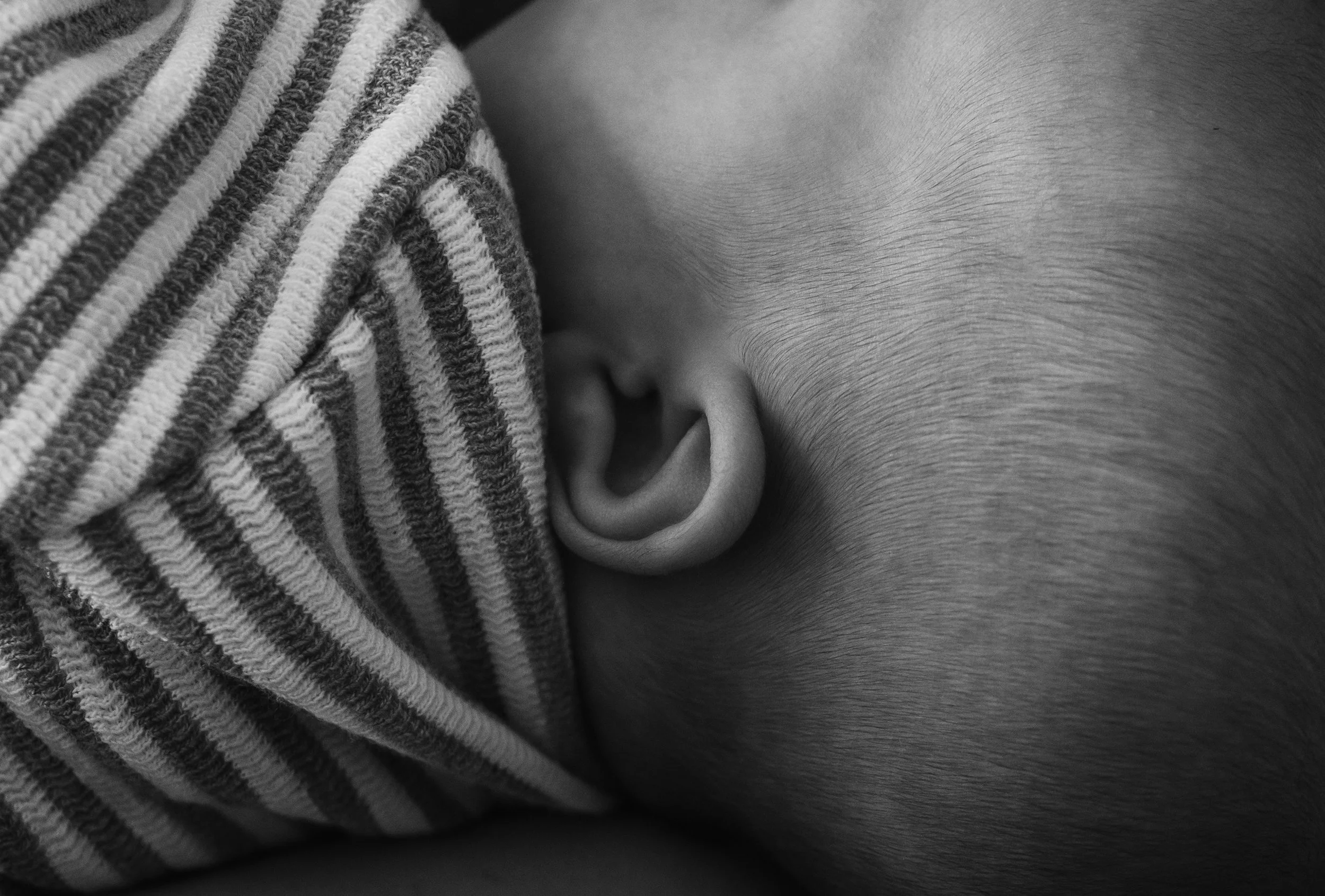 Black and white close up of newborn ear in the first days of life, photographed by Glasgow newborn photographer Marieke Captures Birth