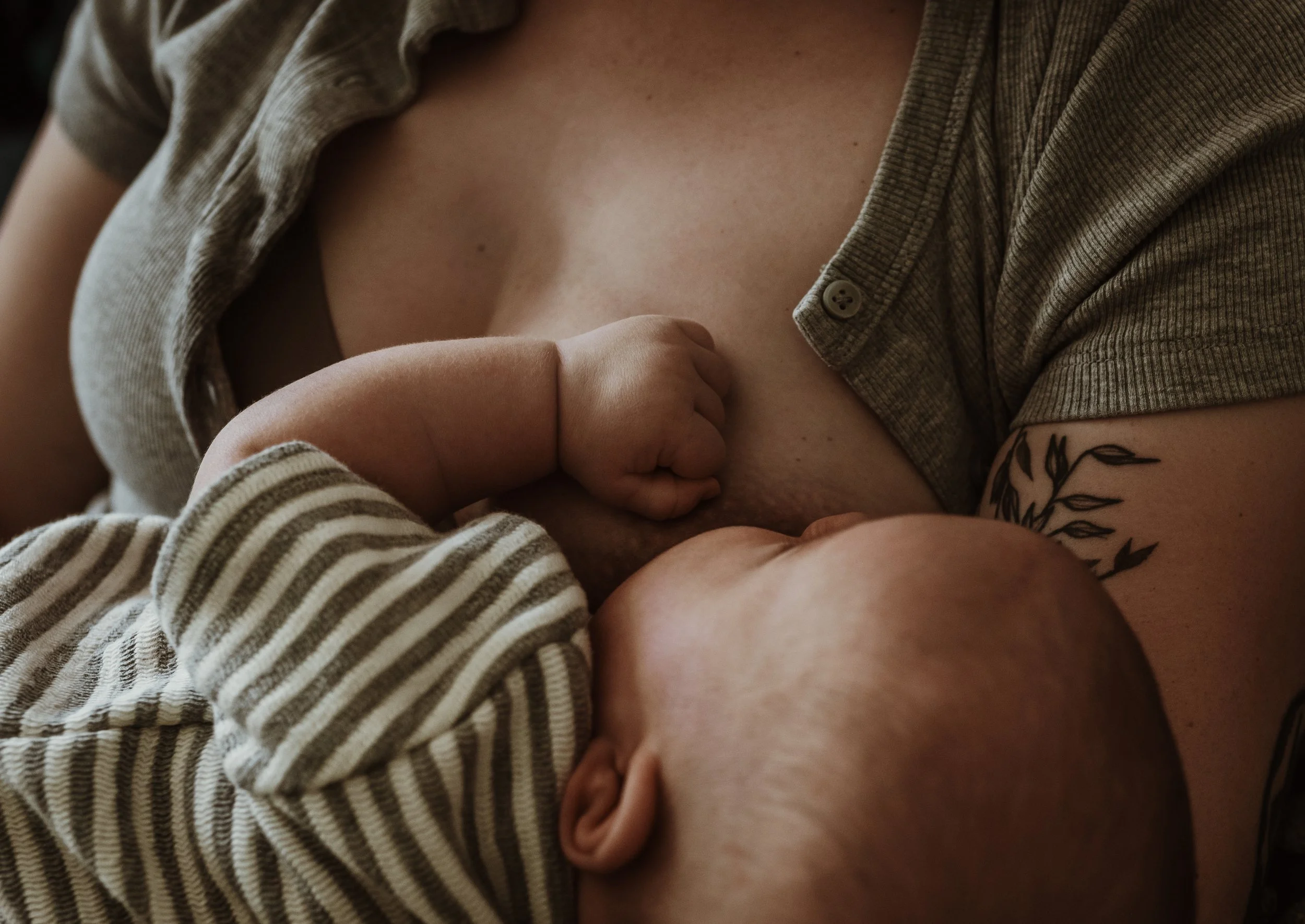 Mother breastfeeding her newborn on a green velvet sofa during a relaxed at-home newborn photography session in Glasgow with Marieke Captures Birth