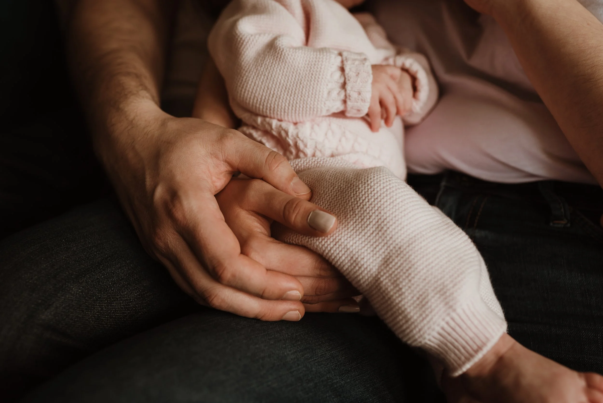 Close up of parent and newborn hands intertwined in a tender moment during a newborn photography session with Glasgow photographer Marieke Captures Birth