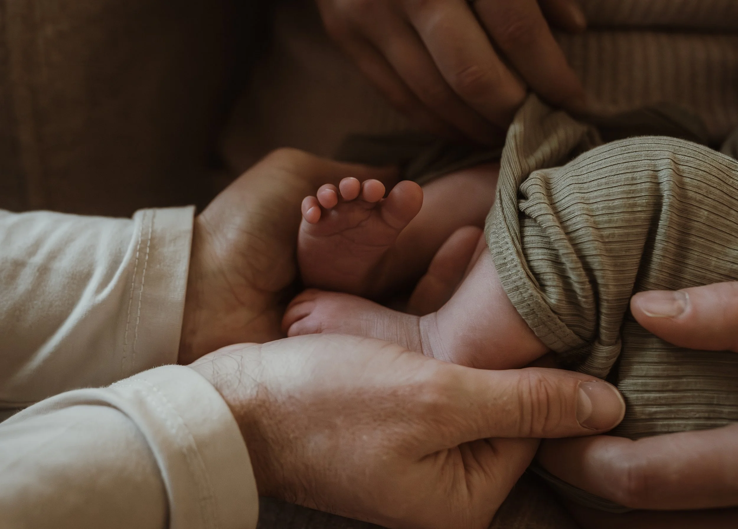Close up of newborn baby feet in a soft green outfit during a newborn photography session with Marieke Captures Birth Glasgow