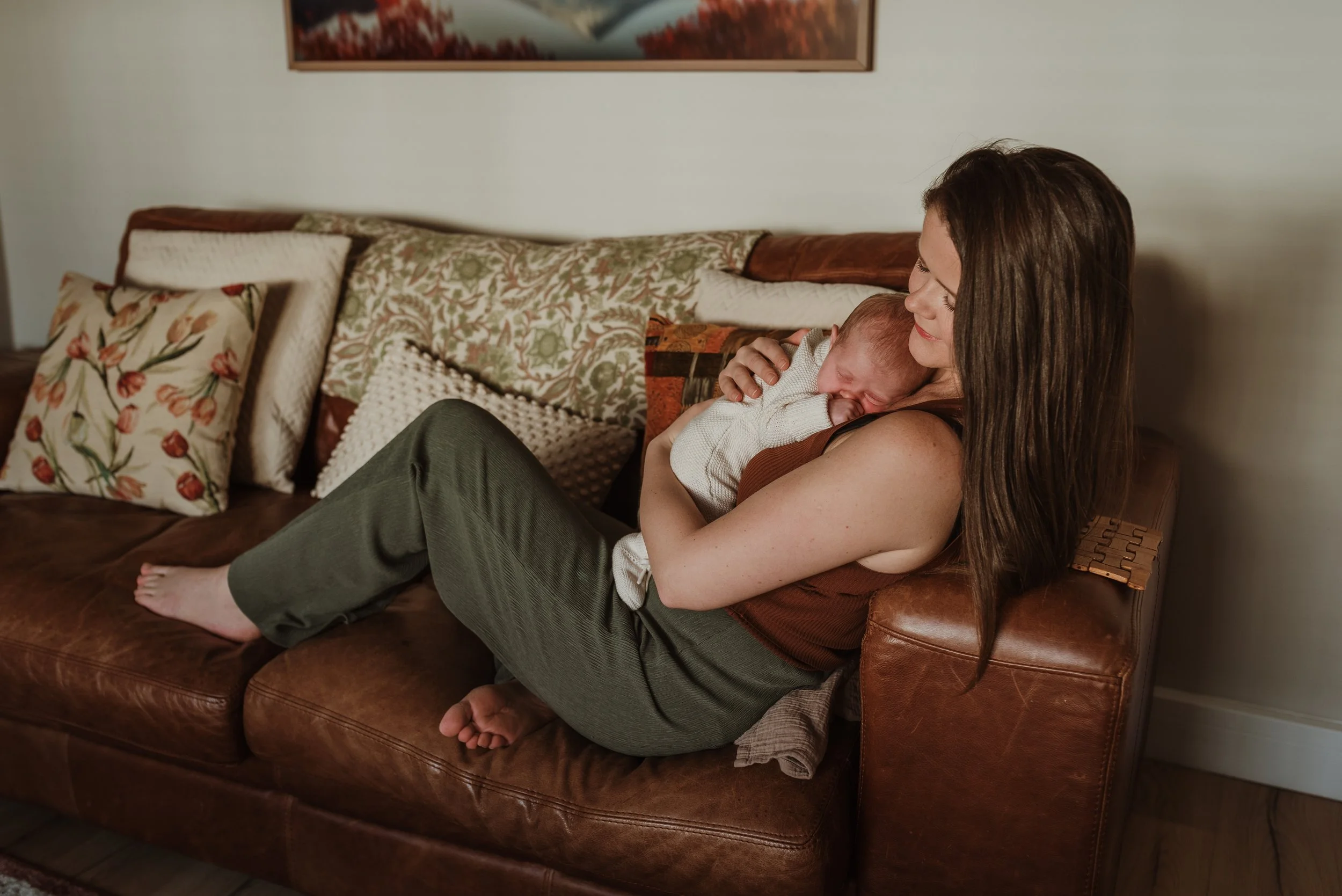 Newborn baby sleeping on mother's chest at home during at-home newborn photography session in Glasgow