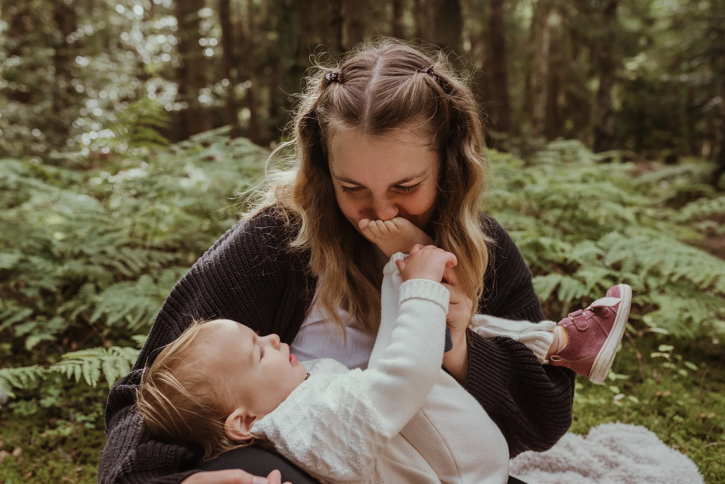 Mother and toddler sharing a joyful moment together outdoors during a nursing photography session in Scotland with Marieke Captures Birth