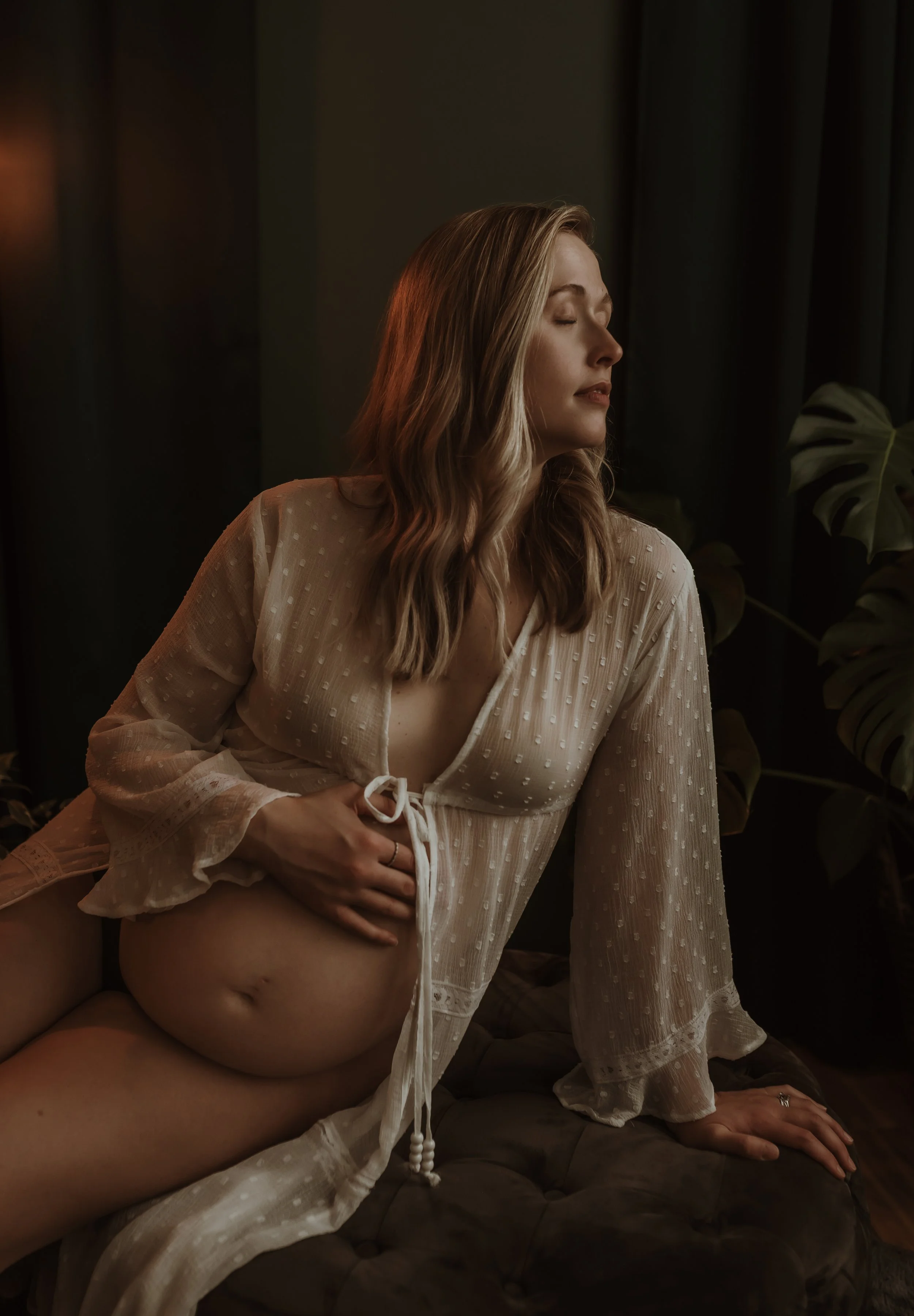 Pregnant woman in a sheer white gown with eyes closed in a moment of calm during a studio maternity session with Glasgow maternity photographer Marieke Captures Birth