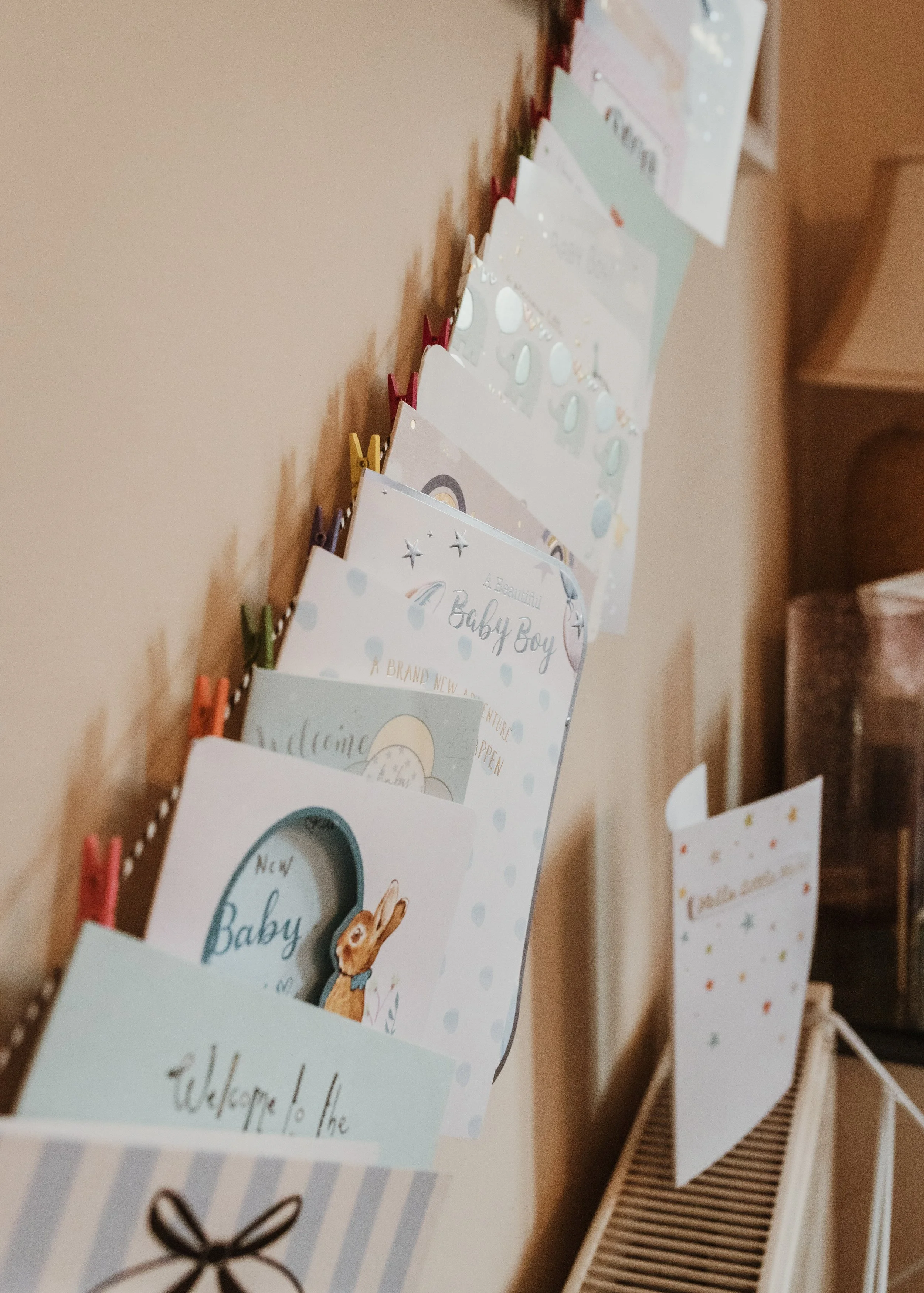 Display of baby congratulations cards in a family home documented during an at-home newborn photography session with Glasgow photographer Marieke Captures Birth