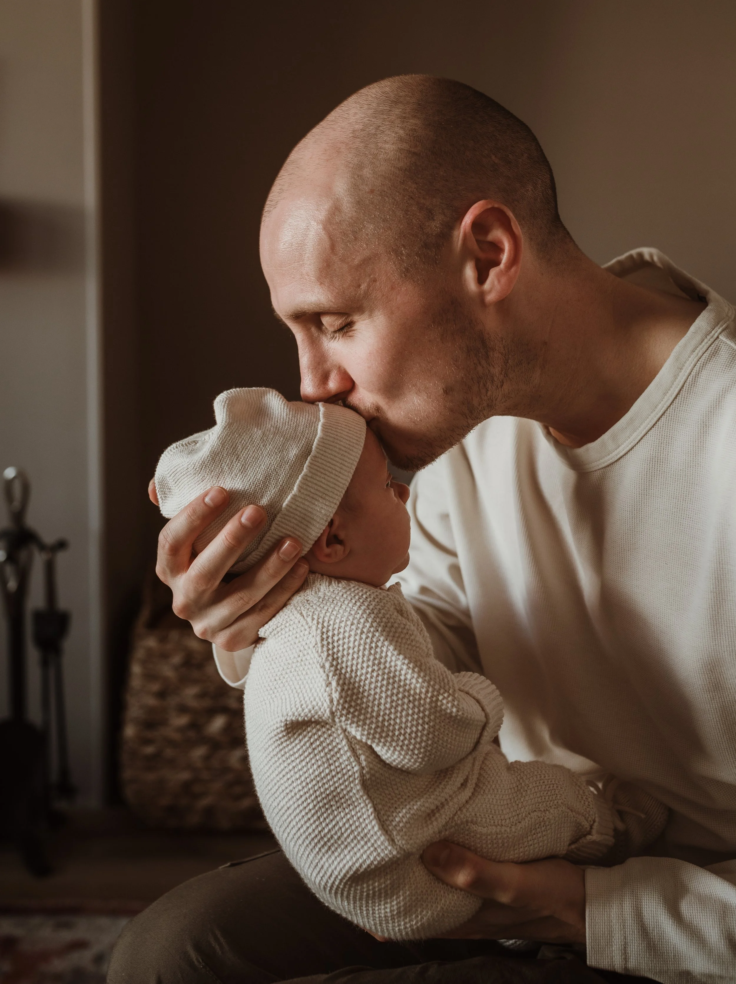 Newborn photography in Glasgow showing parents gently holding their baby during a relaxed at-home newborn photoshoot.