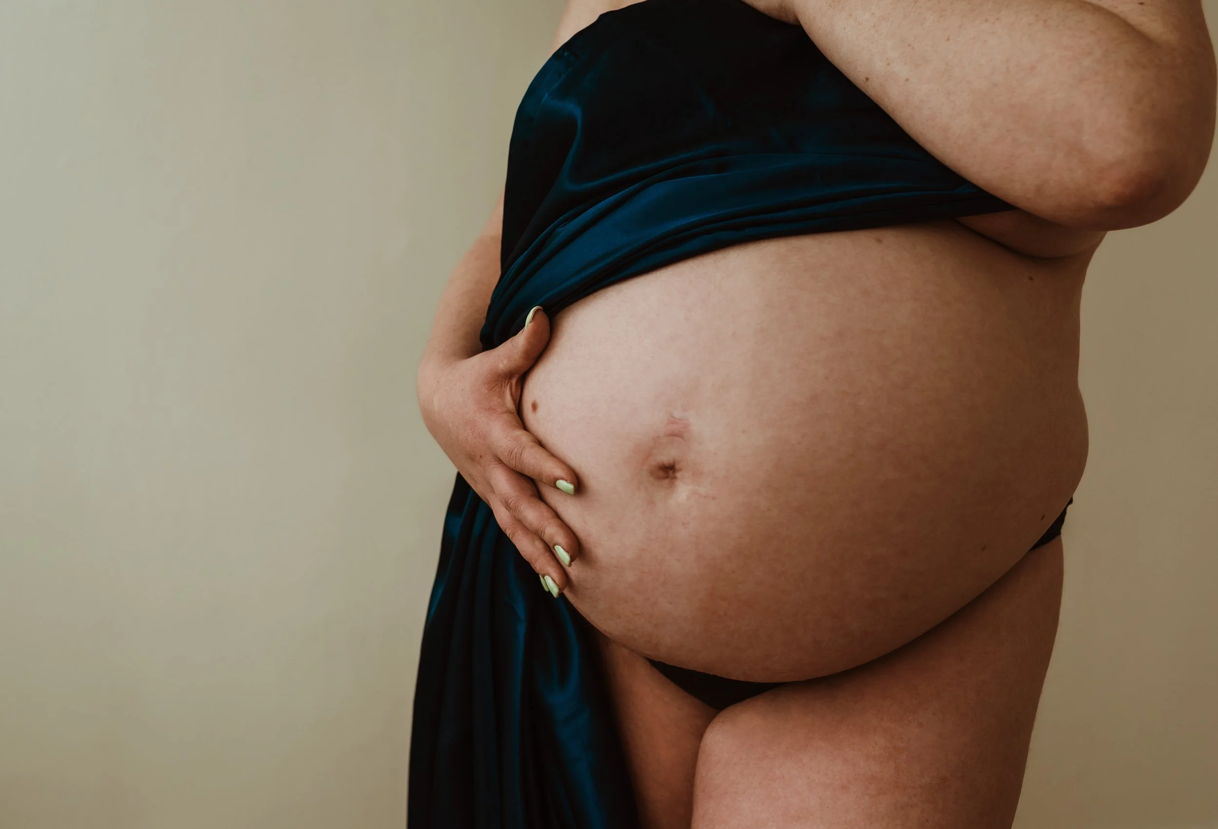 Close up of Jenn's pregnant belly during their maternity session in Glasgow ahead of their birth at Princess Royal Maternity Hospital